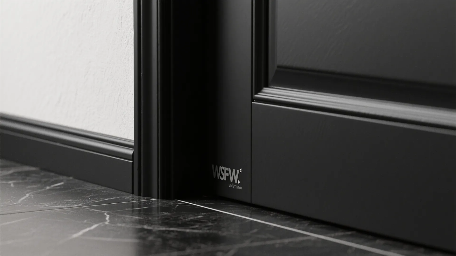 Black door frame and wall panel meeting a dark marble floor in a modern room