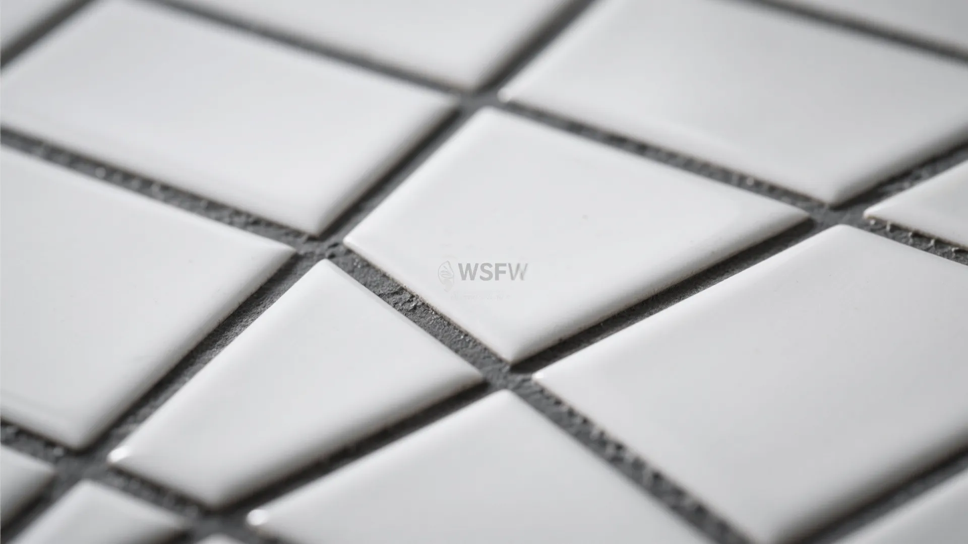 Close up of white rectangular tiles with dark grey grout lines on a modern wall