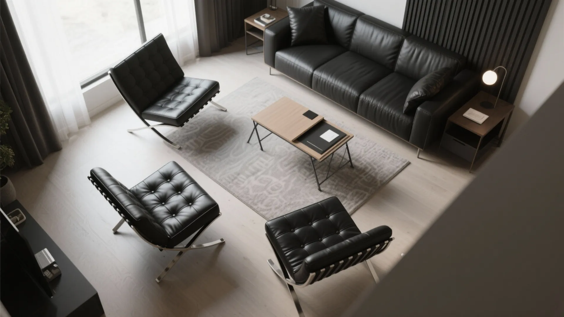 Layout showing black leather chairs angled toward a sofa to form a conversation triangle and a nearby multifunction desk.