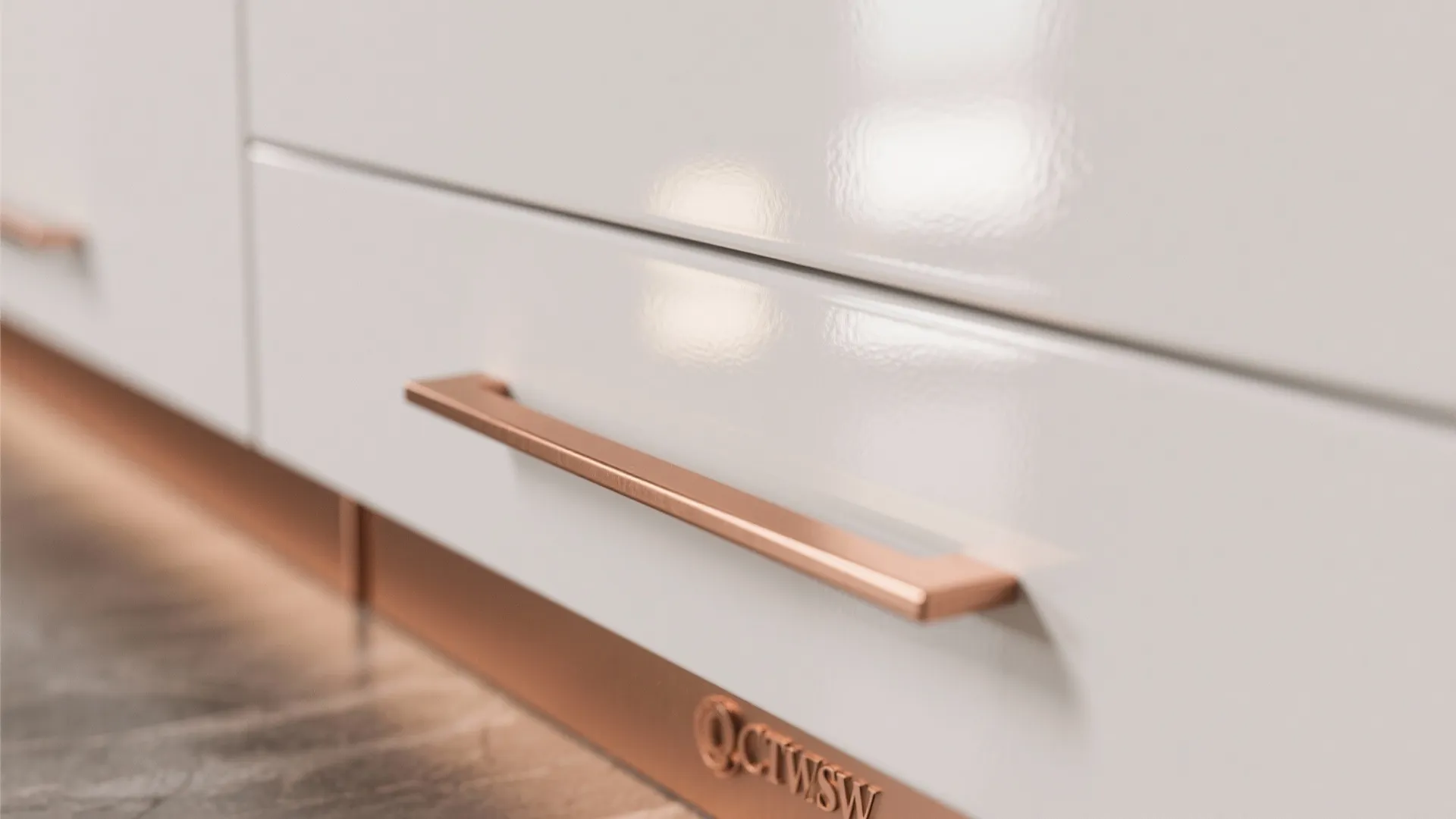 Close up of a copper handle on white kitchen drawer with matching copper base trim
