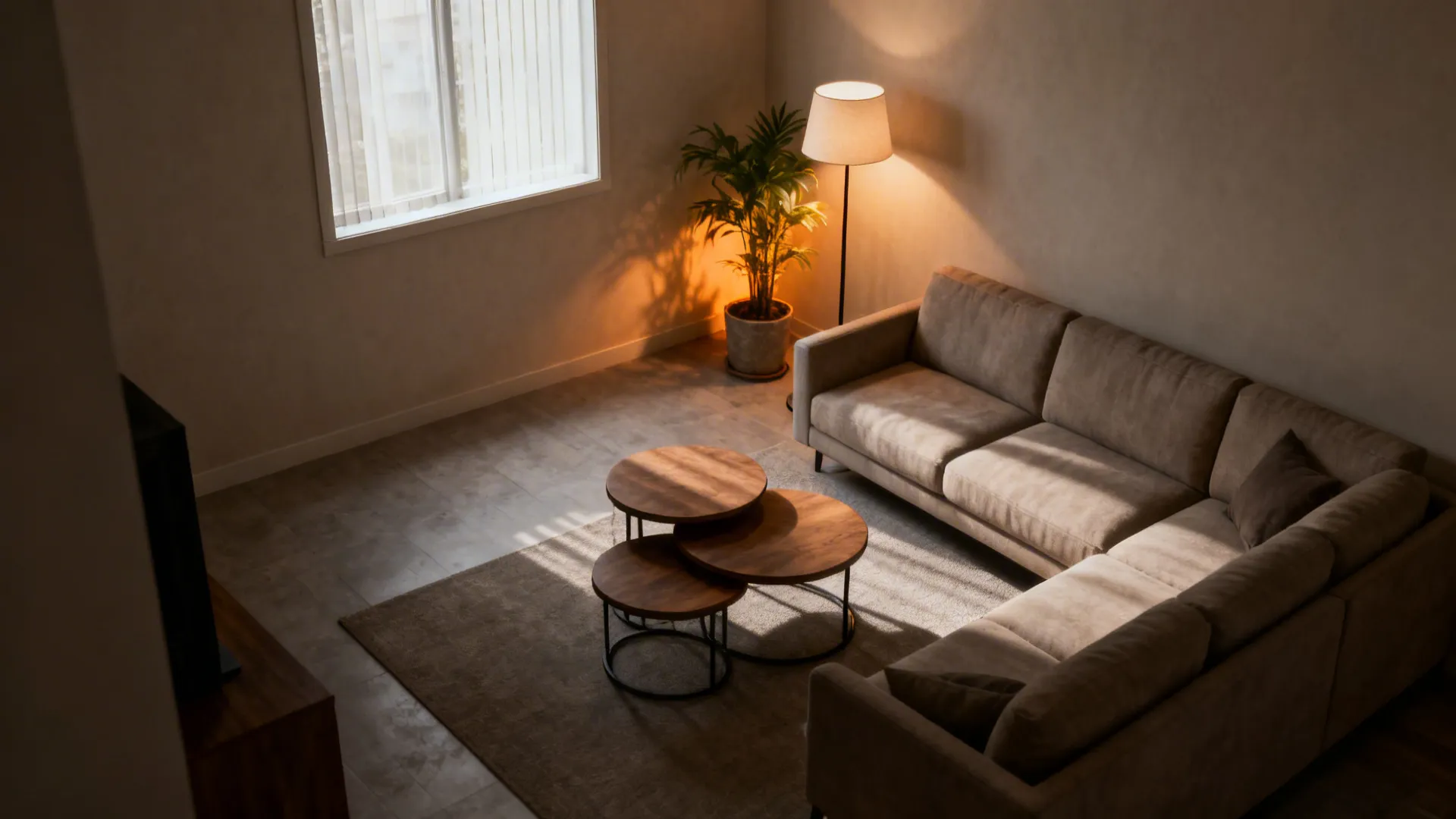 L-shaped sofa anchored in a corner leaving the center open, with nesting tables and a floor lamp.