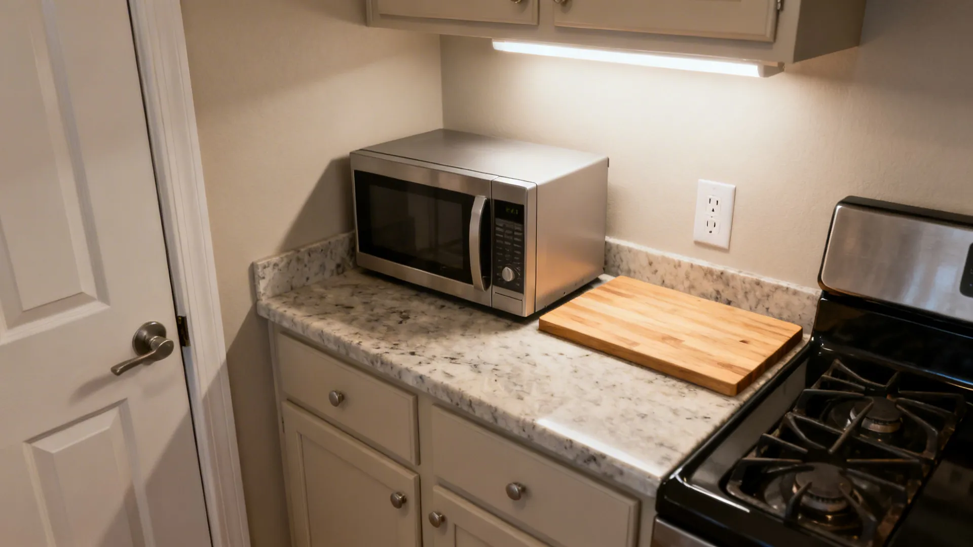 Diagonal corner microwave with a small landing board and under-cabinet lighting.