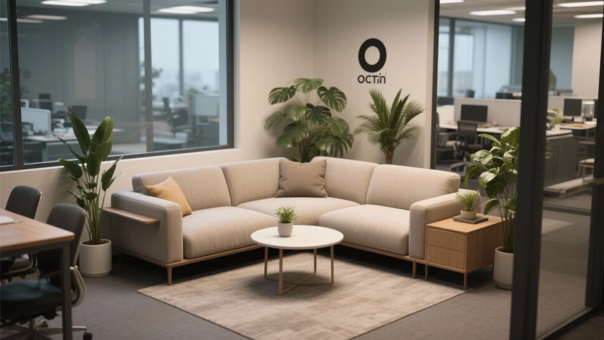 Corner sofa with round coffee table and green plants in a clean modern office lounge