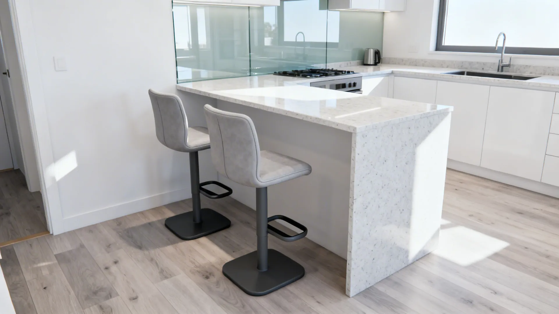 White kitchen island with two grey stools marble countertop wood floor and bright natural sunlight