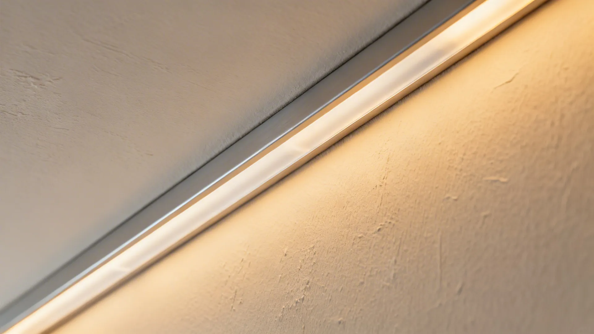 Close-up of aluminum LED channel with diffuser in a gypsum cove showing even warm glow.
