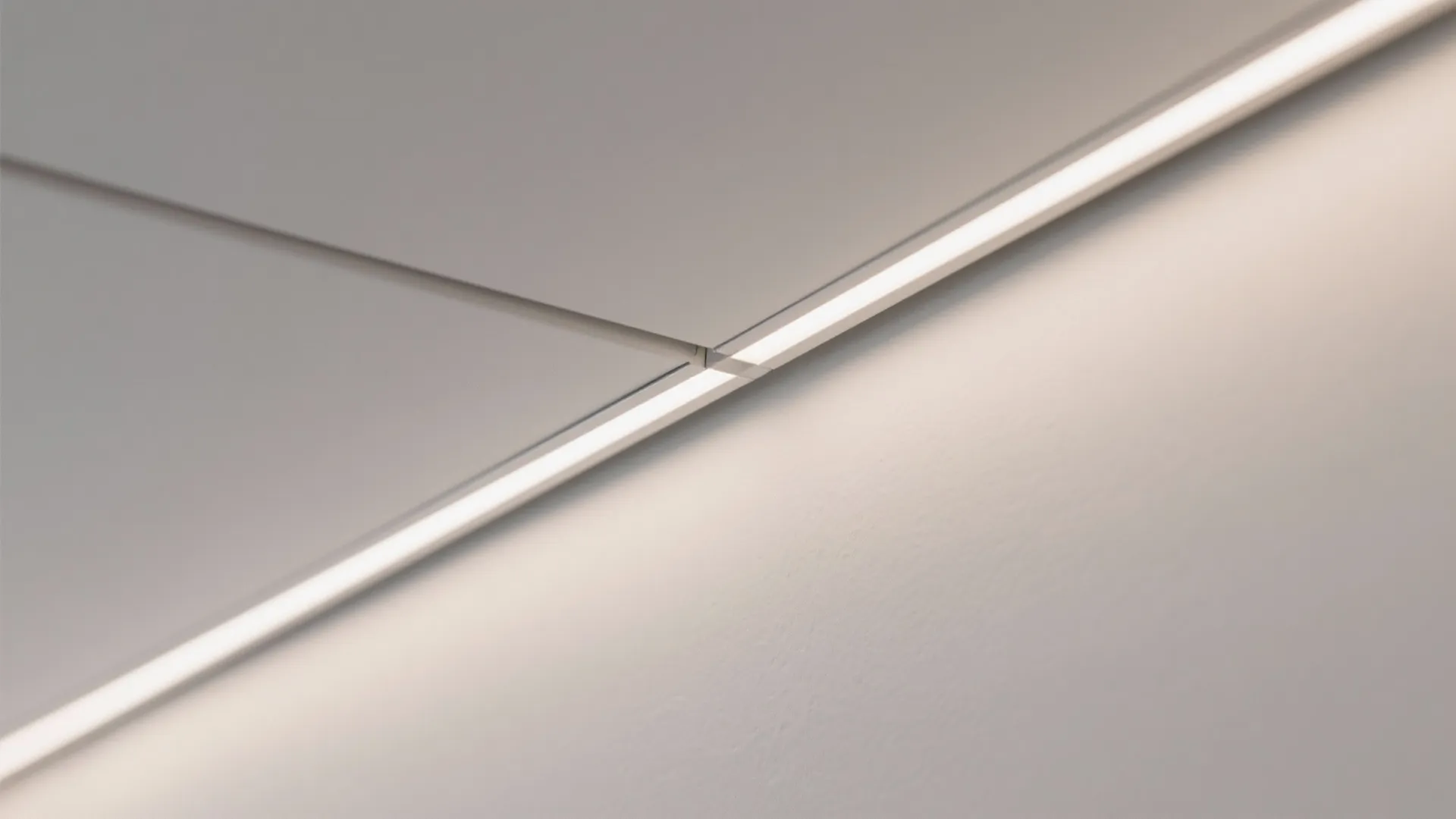 Close up view of modern linear light fixture integrated into a clean white ceiling corner
