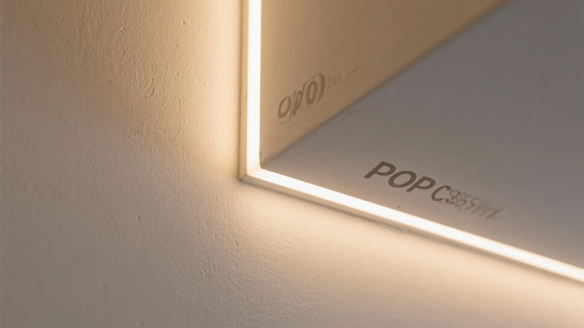 Close up view of a wall light strip installed inside a recessed white ceiling corner