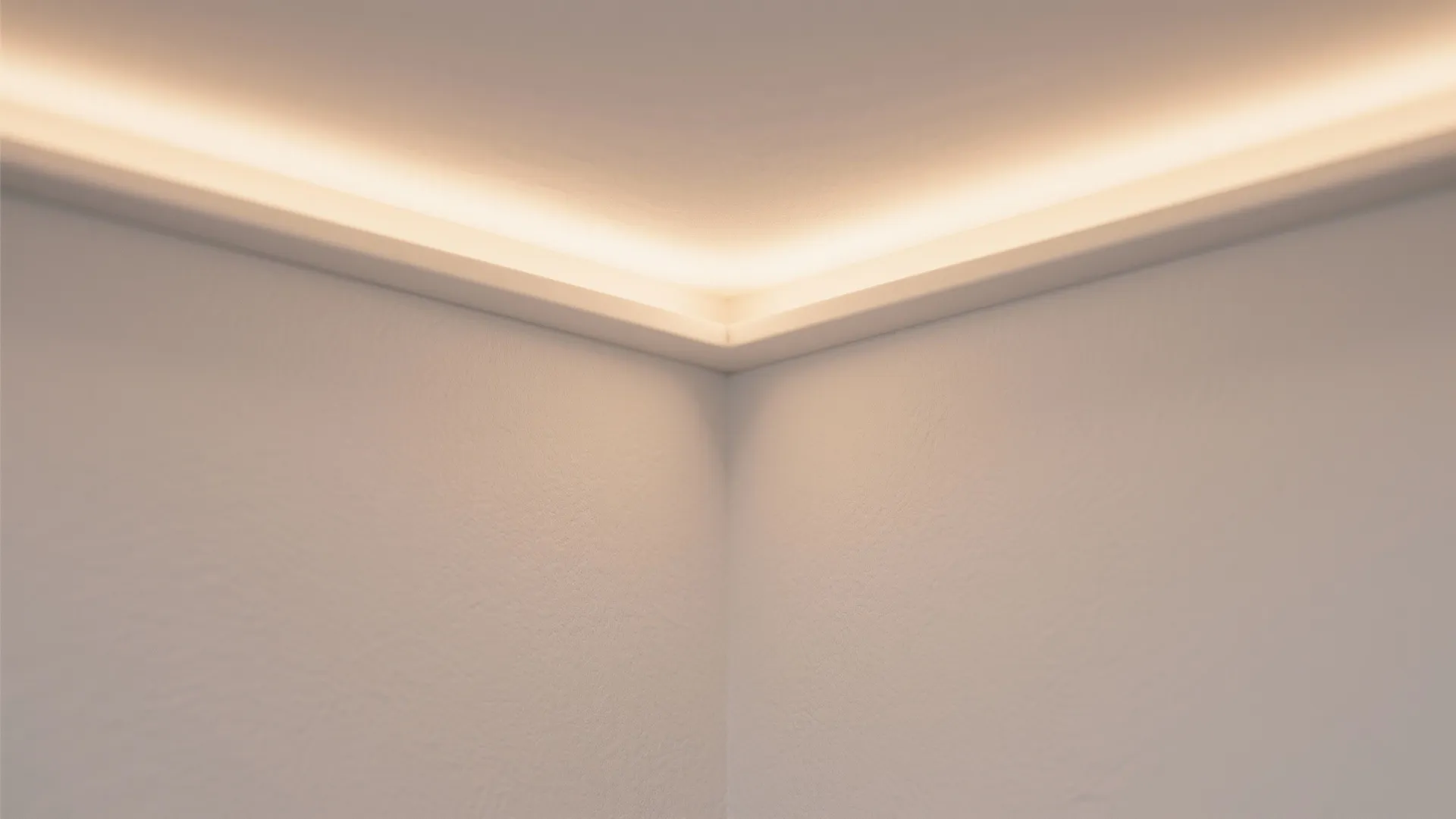 Close up of warm hidden light strips installed along the top edge of white wall corner