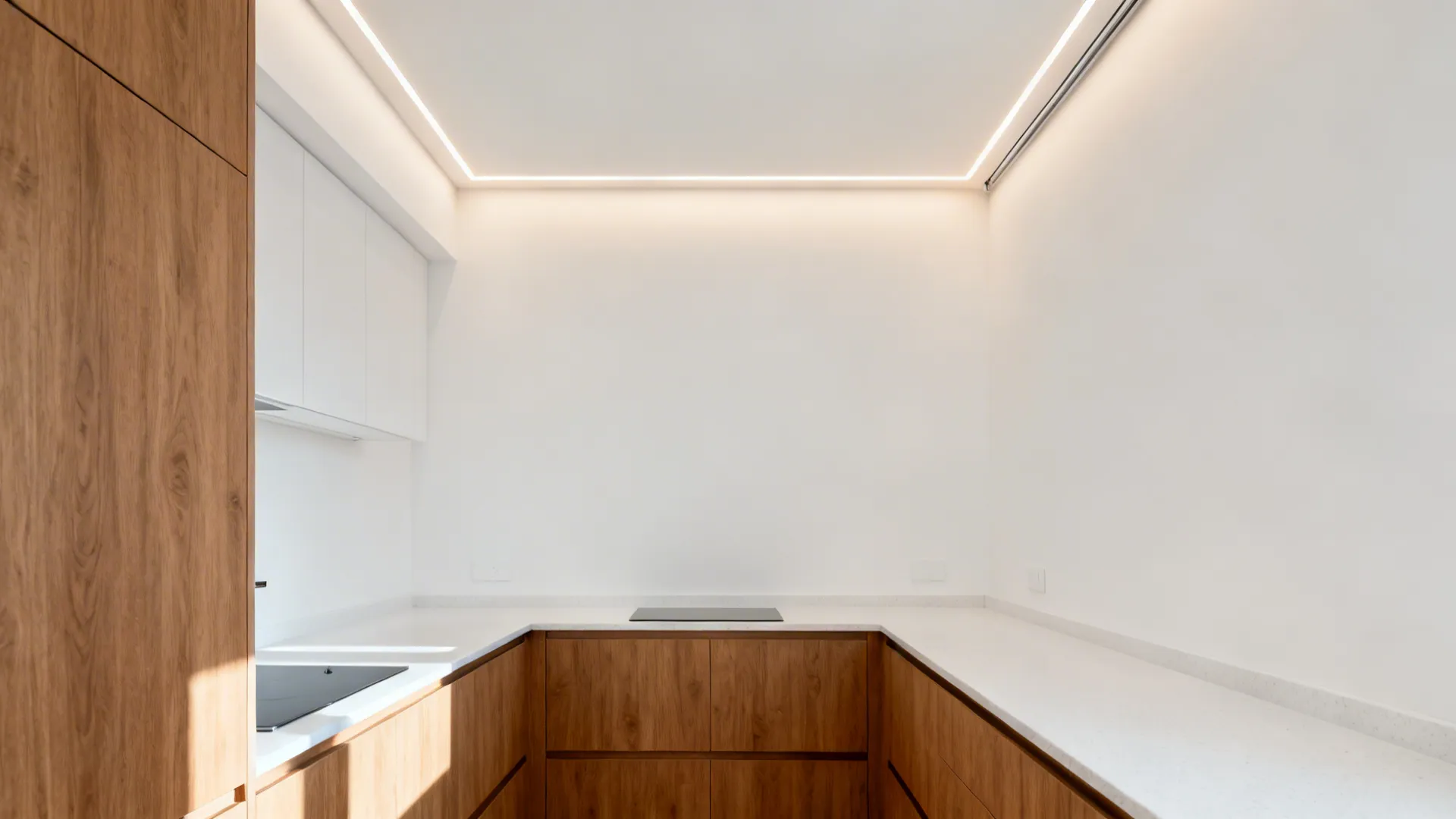 Small galley kitchen with a shallow perimeter cove ceiling casting warm 2700K indirect light over matte surfaces.