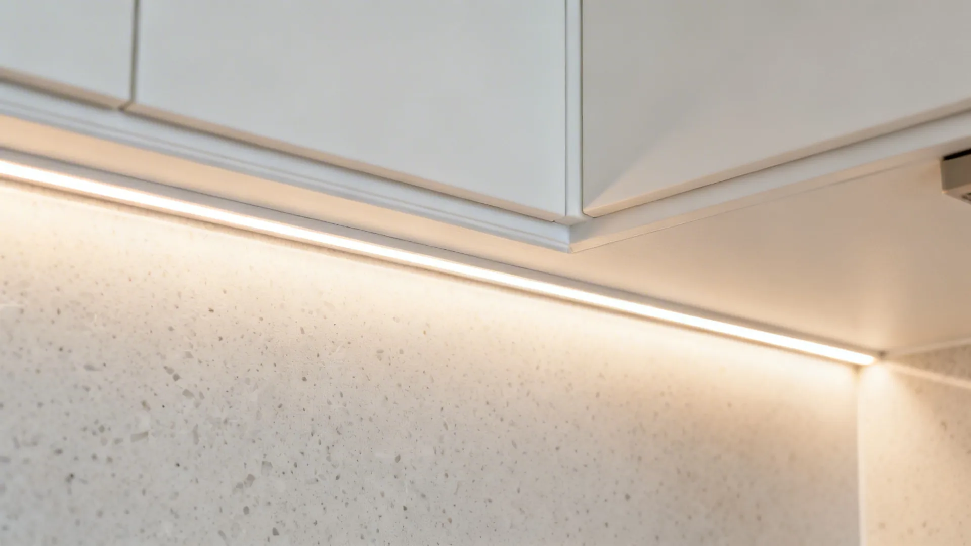 Macro of a gypsum cove with warm LED glow and matte white finish.