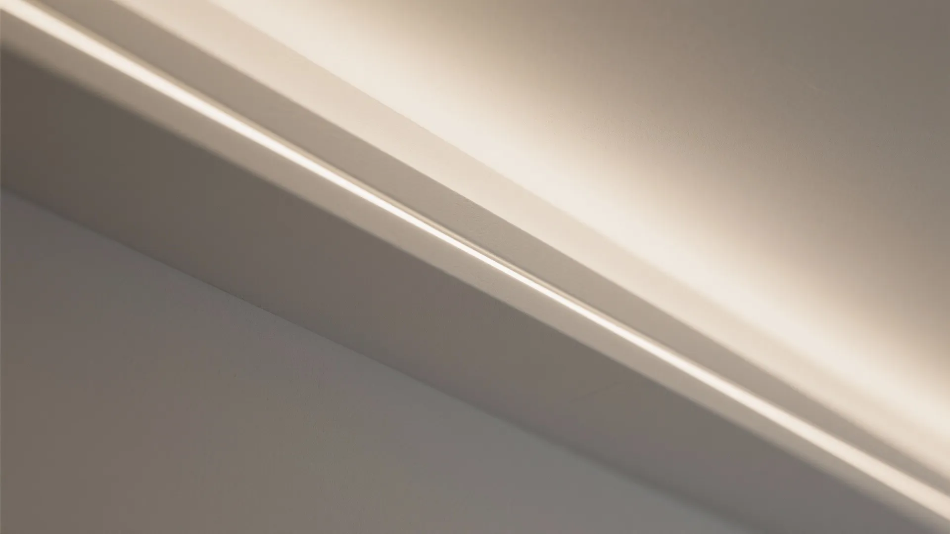 Close up of hidden warm white light fixture strip installed behind a white wall panel