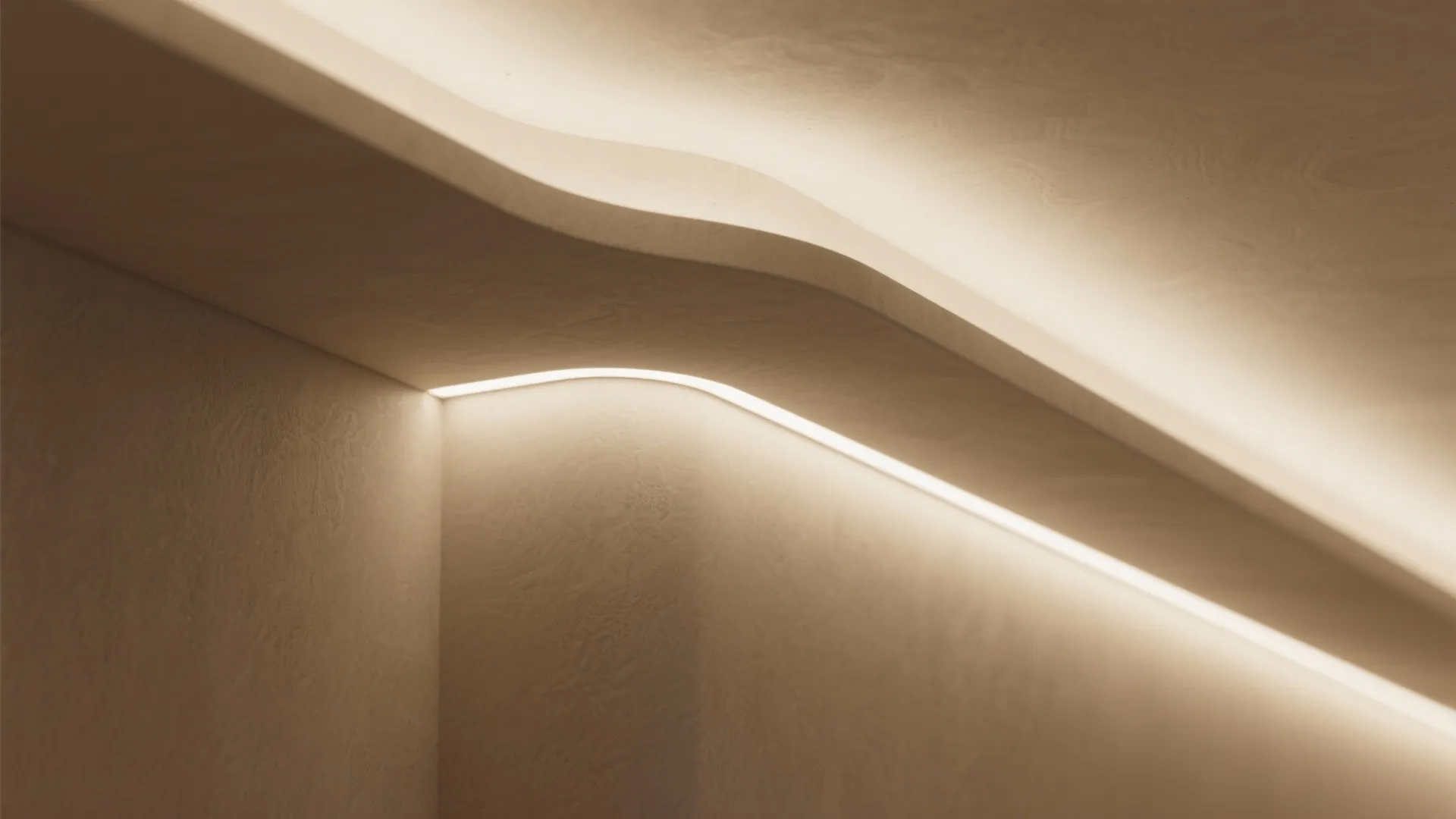 Warm light strip glowing from behind curved ceiling panels to illuminate a simple beige wall