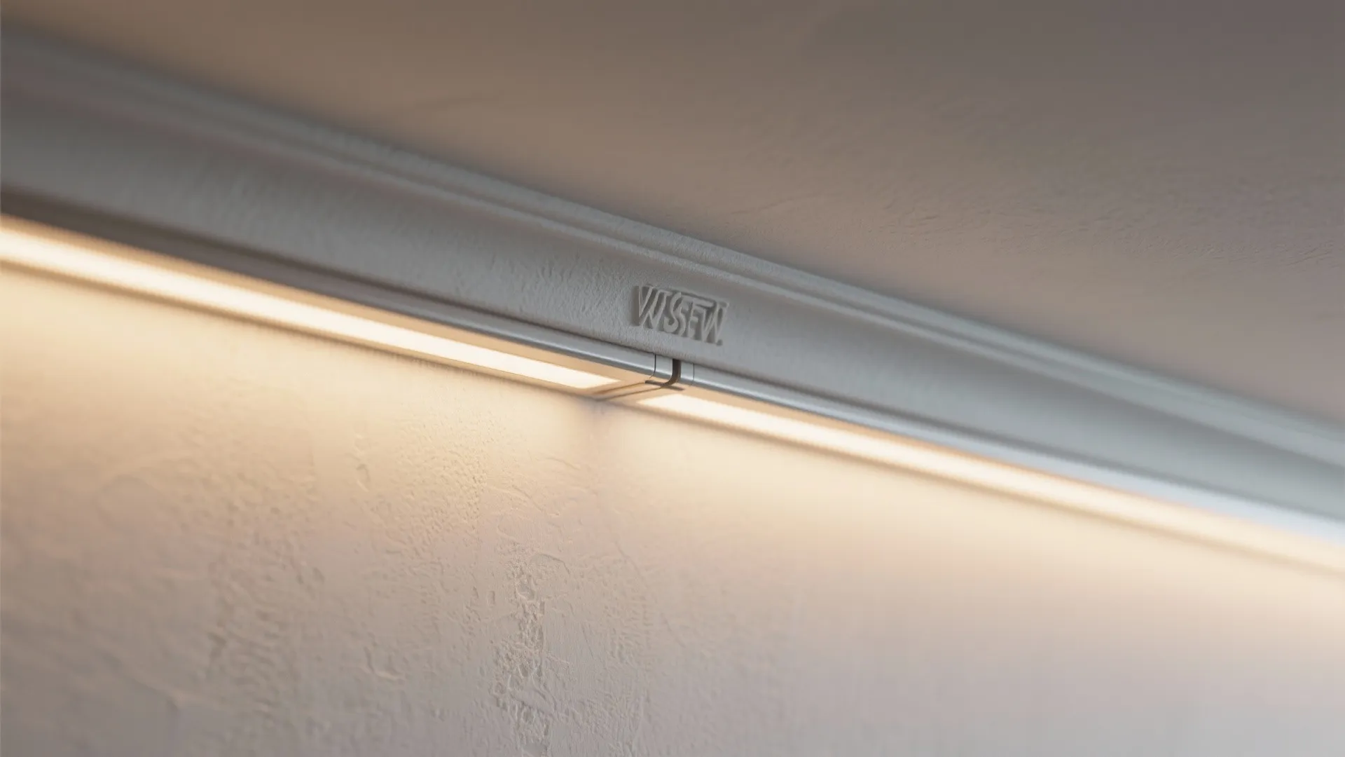 Close up view of long led light strip installed inside a white ceiling wall panel corner