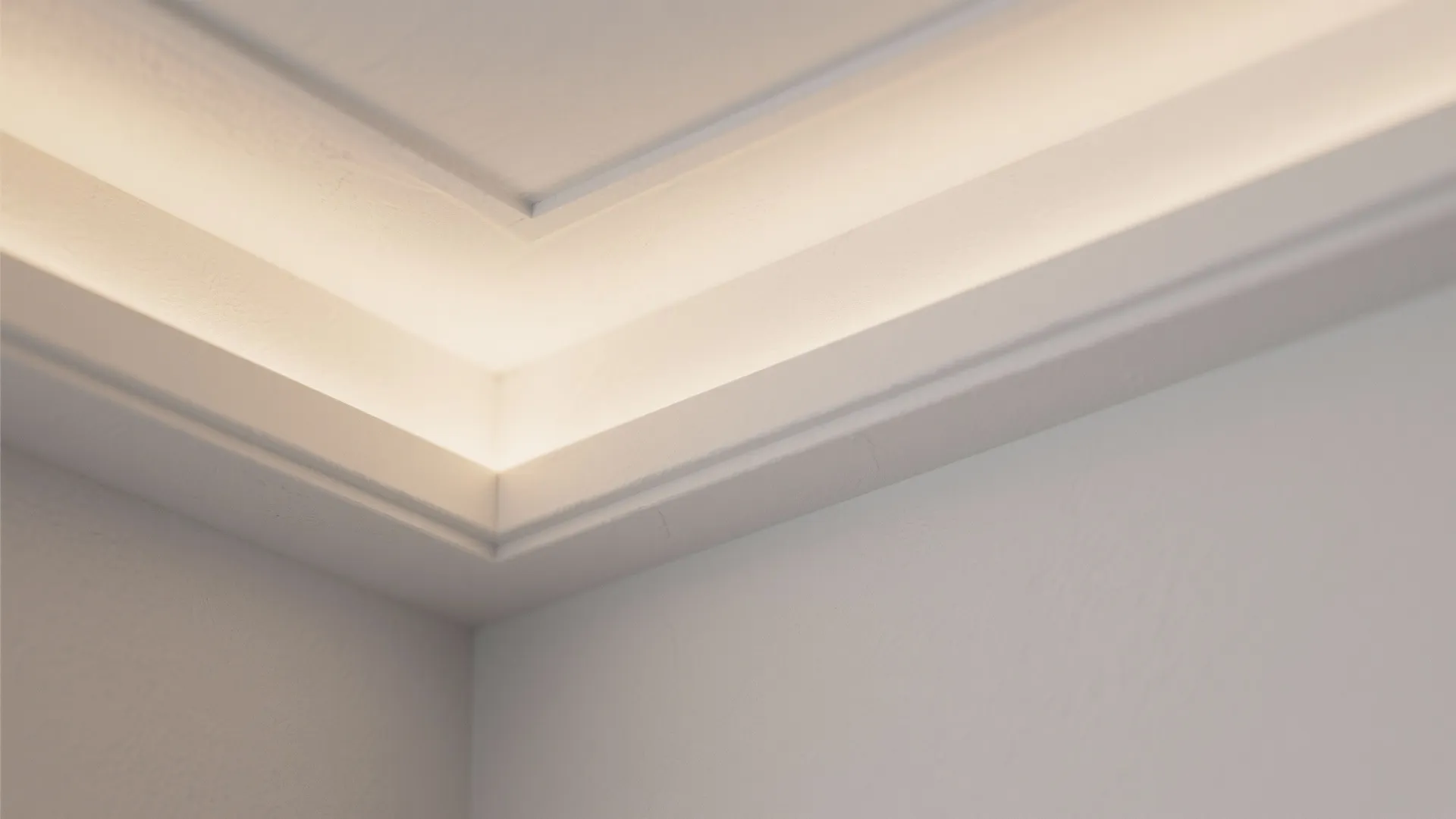 Close up of white wall panel corner with warm hidden light fixture and elegant molding