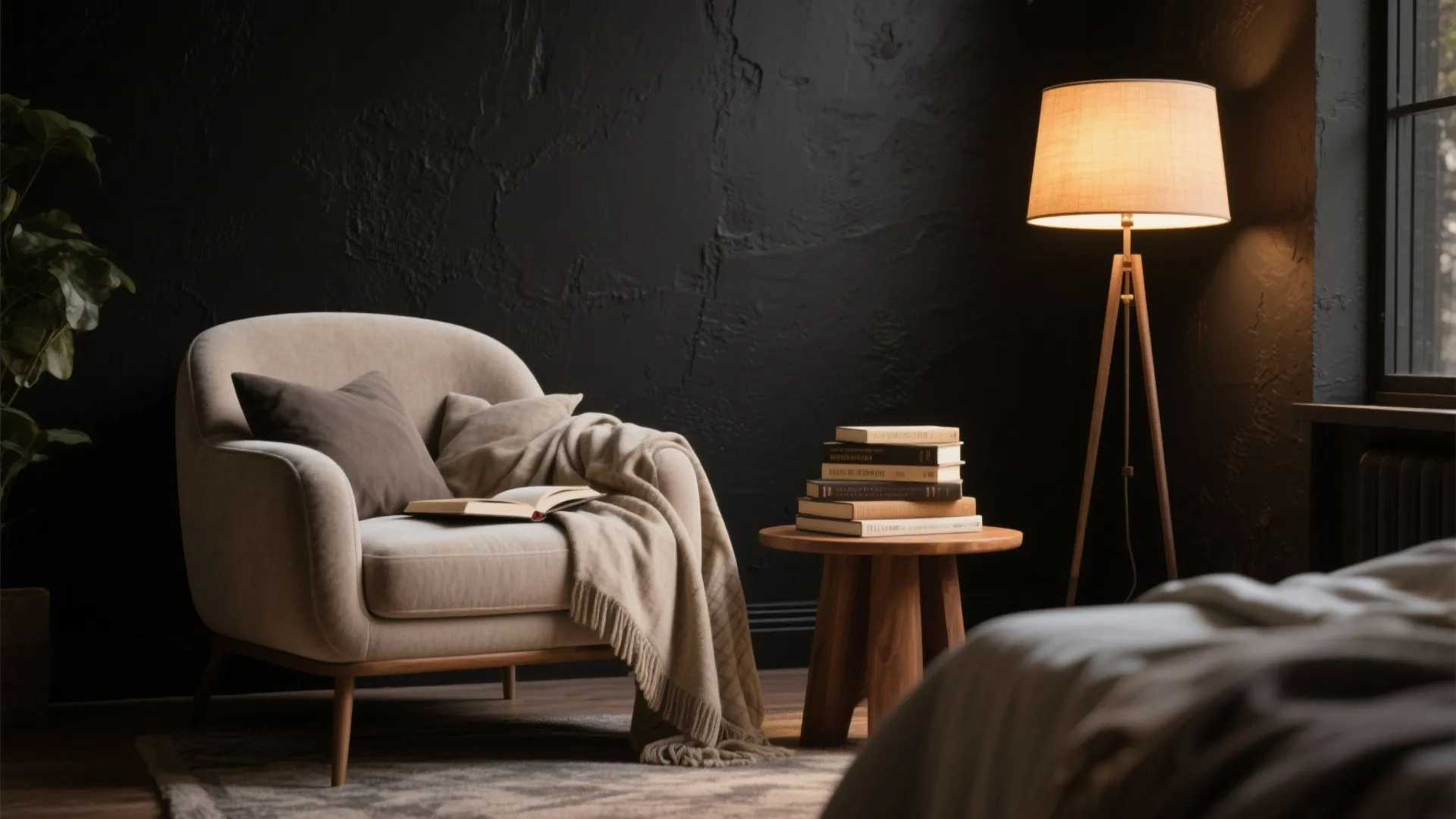 Cozy reading corner with cream armchair, wood side table, books, floor lamp, and black wall