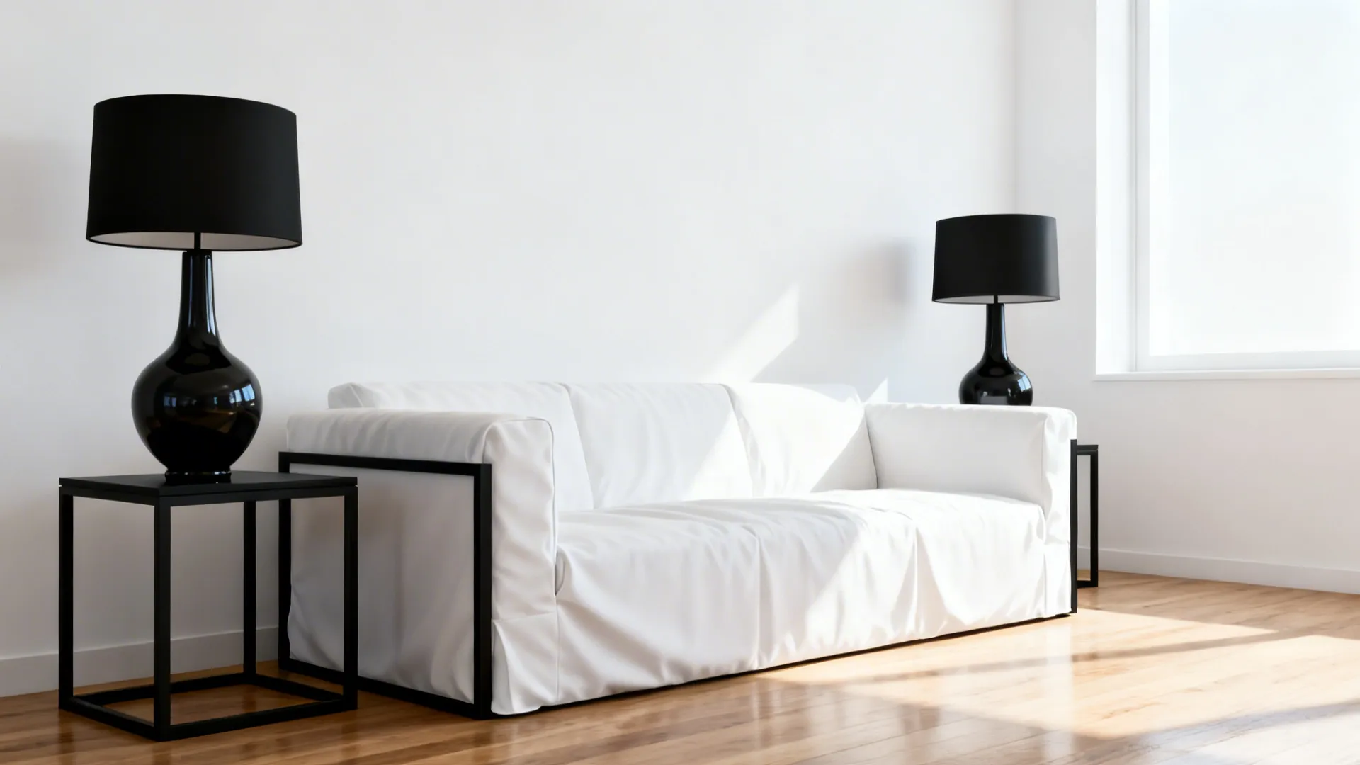 Bright living room featuring white sofa black table lamps side tables wooden floor and sunlight