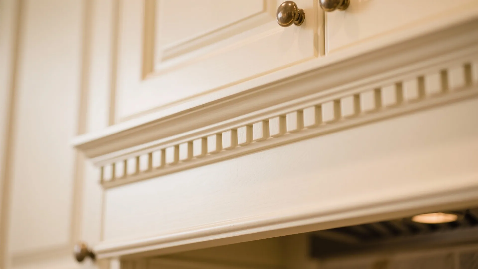 Detailed crown molding above cream-colored kitchen cabinets