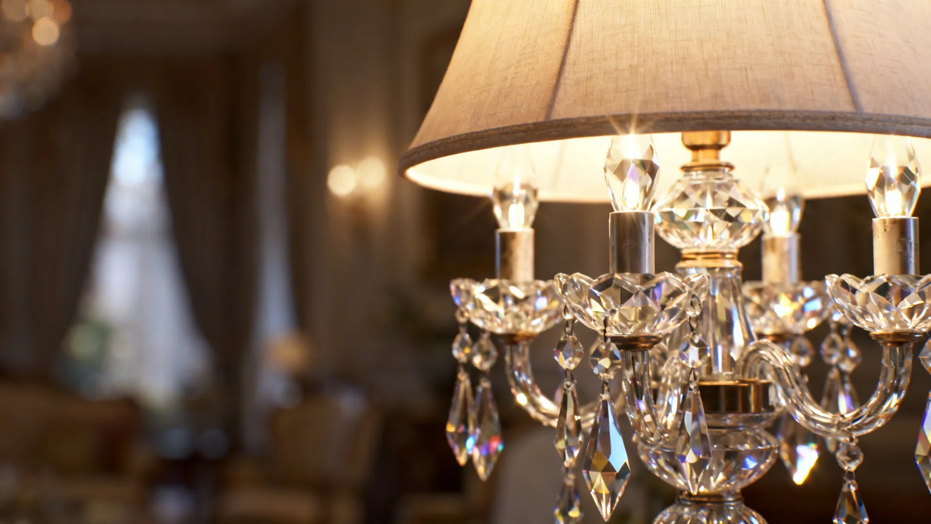 Cut-glass crystal table lamp refracting warm light with a linen shade