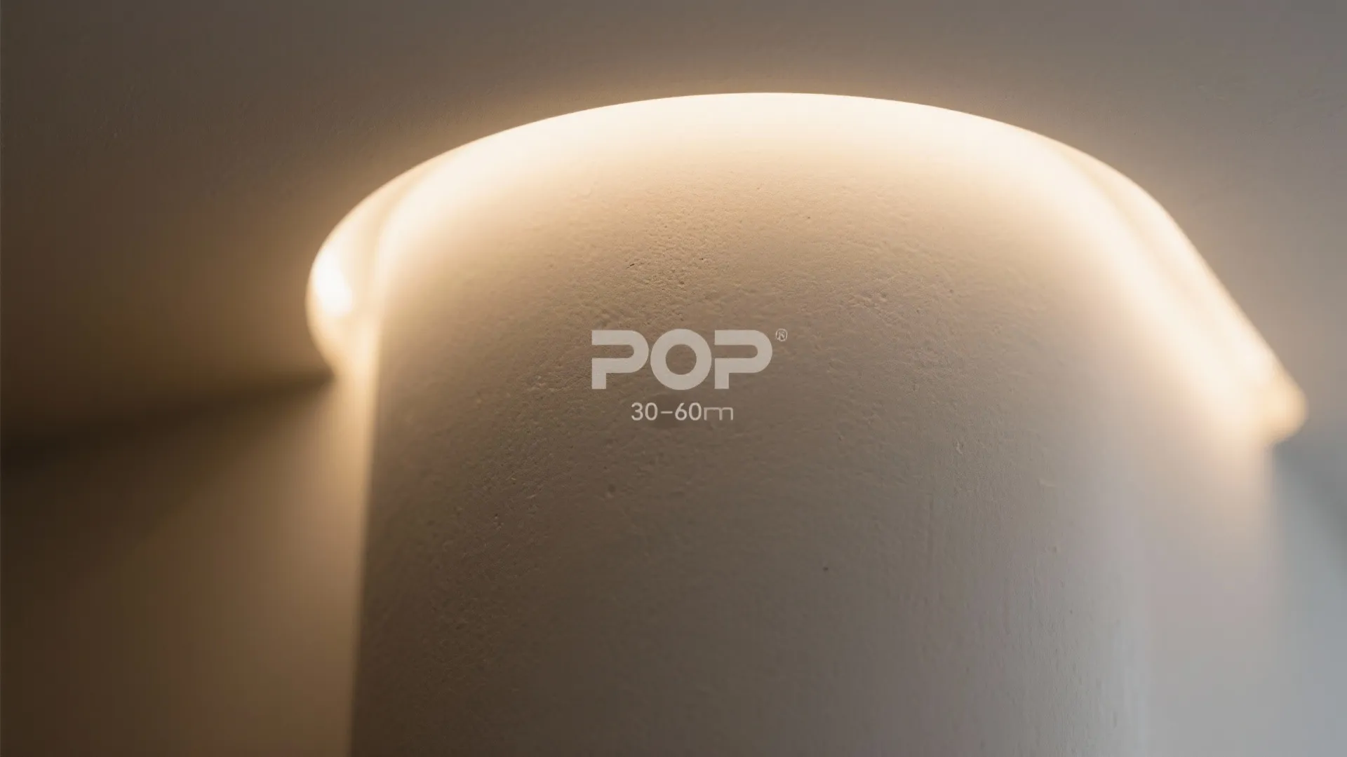 Close up of a curved white wall with hidden warm light fixture and smooth surface