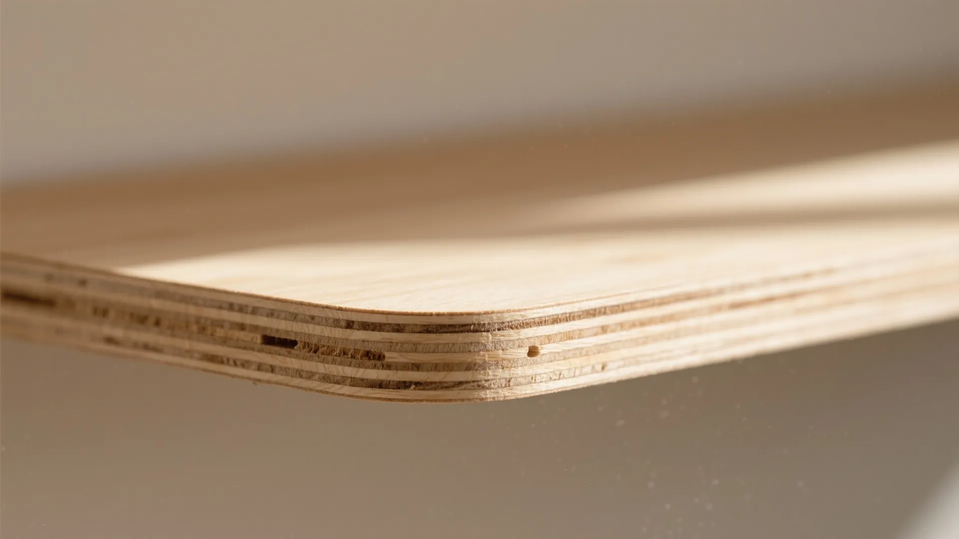 Close up view of a wooden board corner showing layered texture and smooth rounded edge