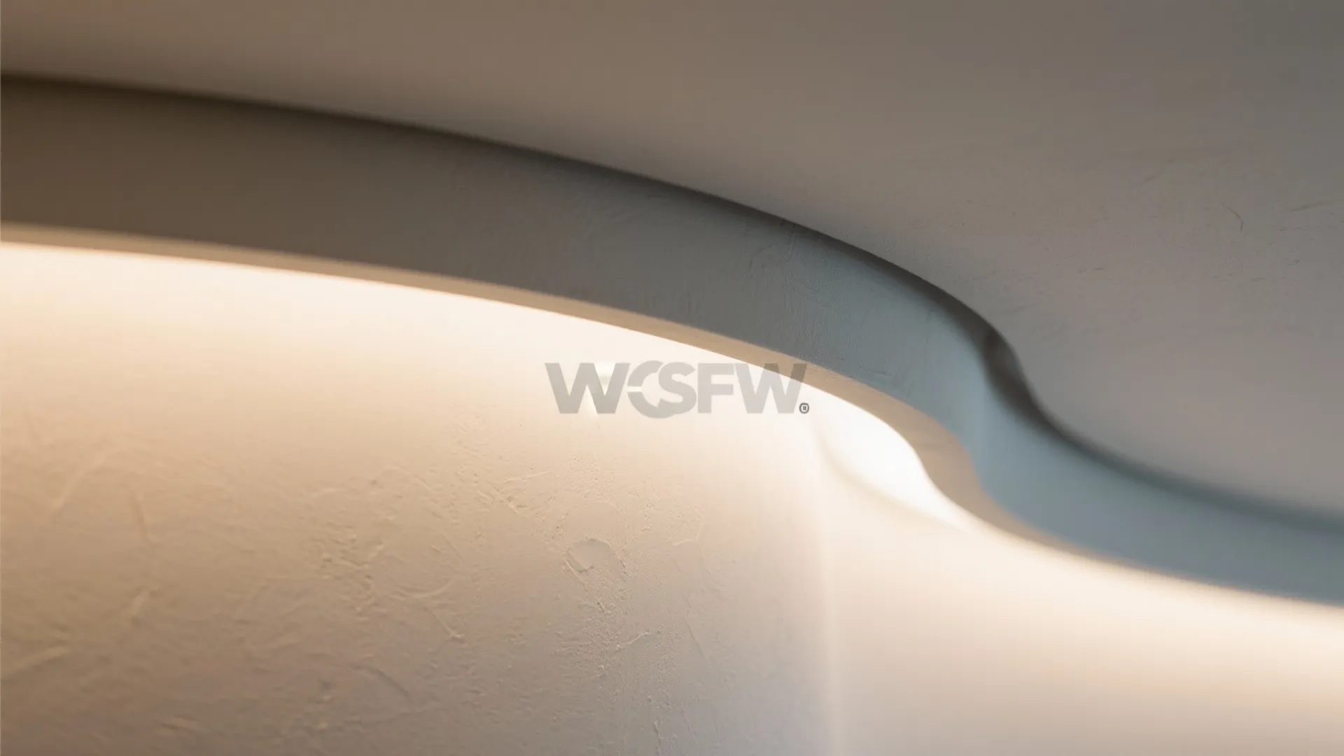 Detailed view of curved white ceiling edge with soft hidden warm light strip glow effect