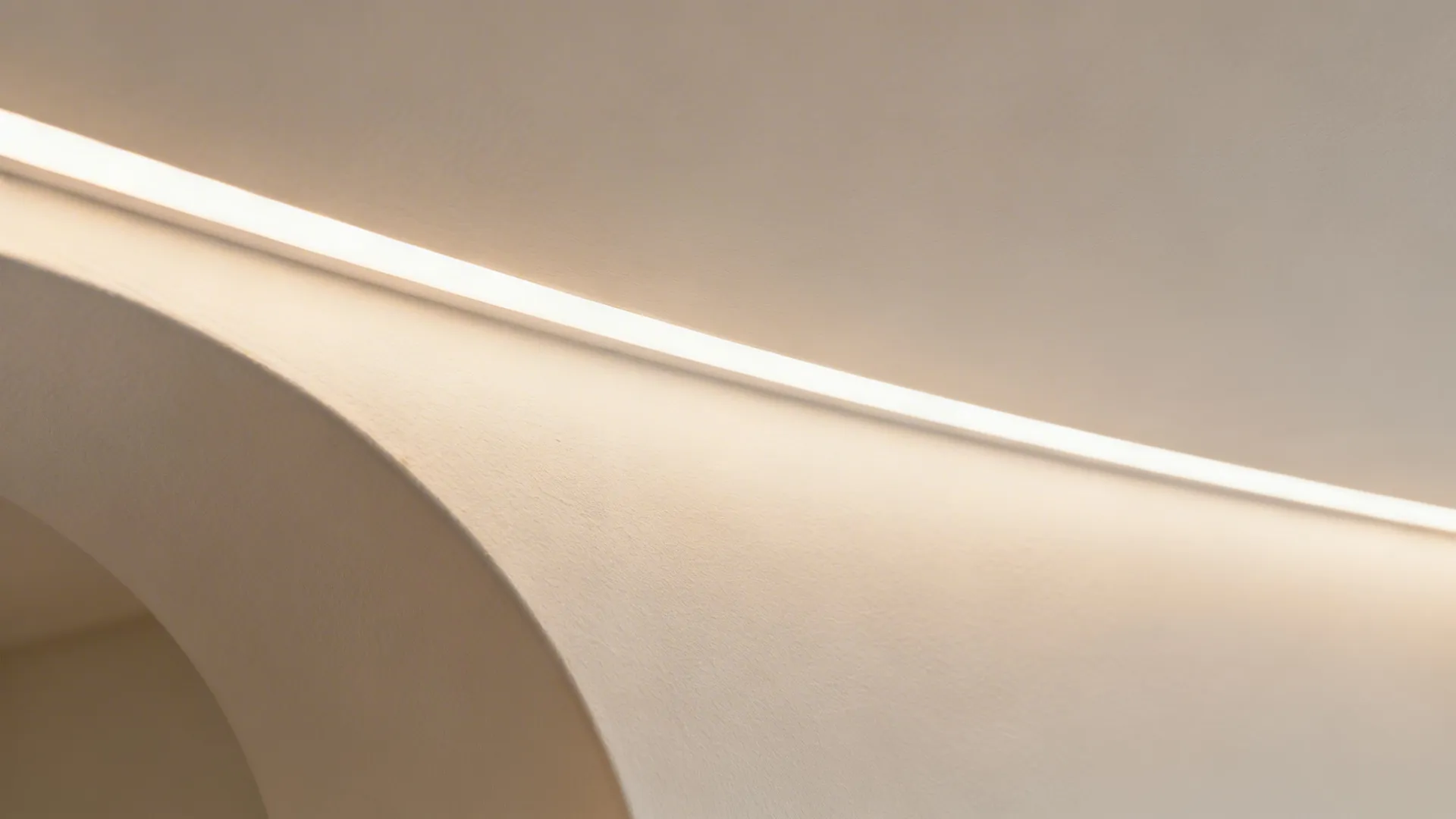 Close up view of a curved ceiling edge featuring a built in bright light strip