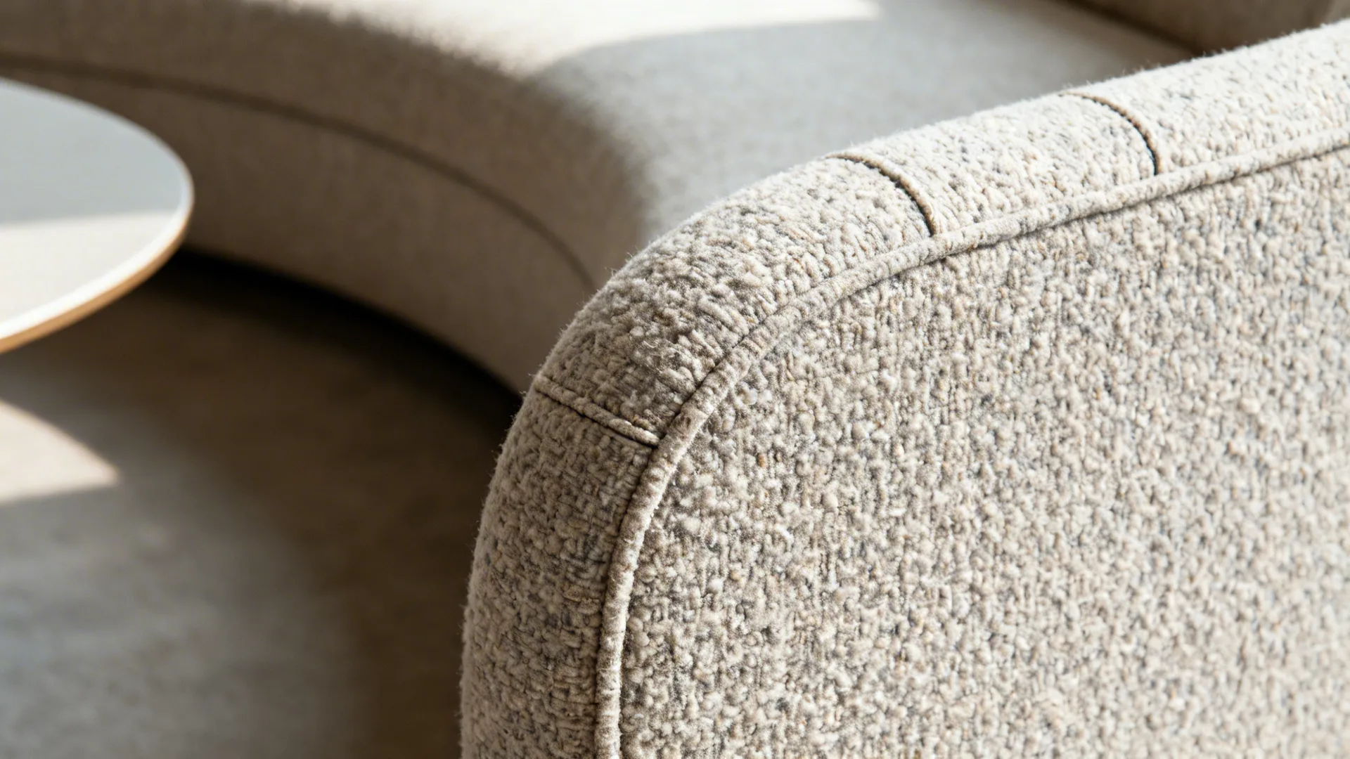 Macro of curved sofa radius with textured bouclé fabric and clean seam.