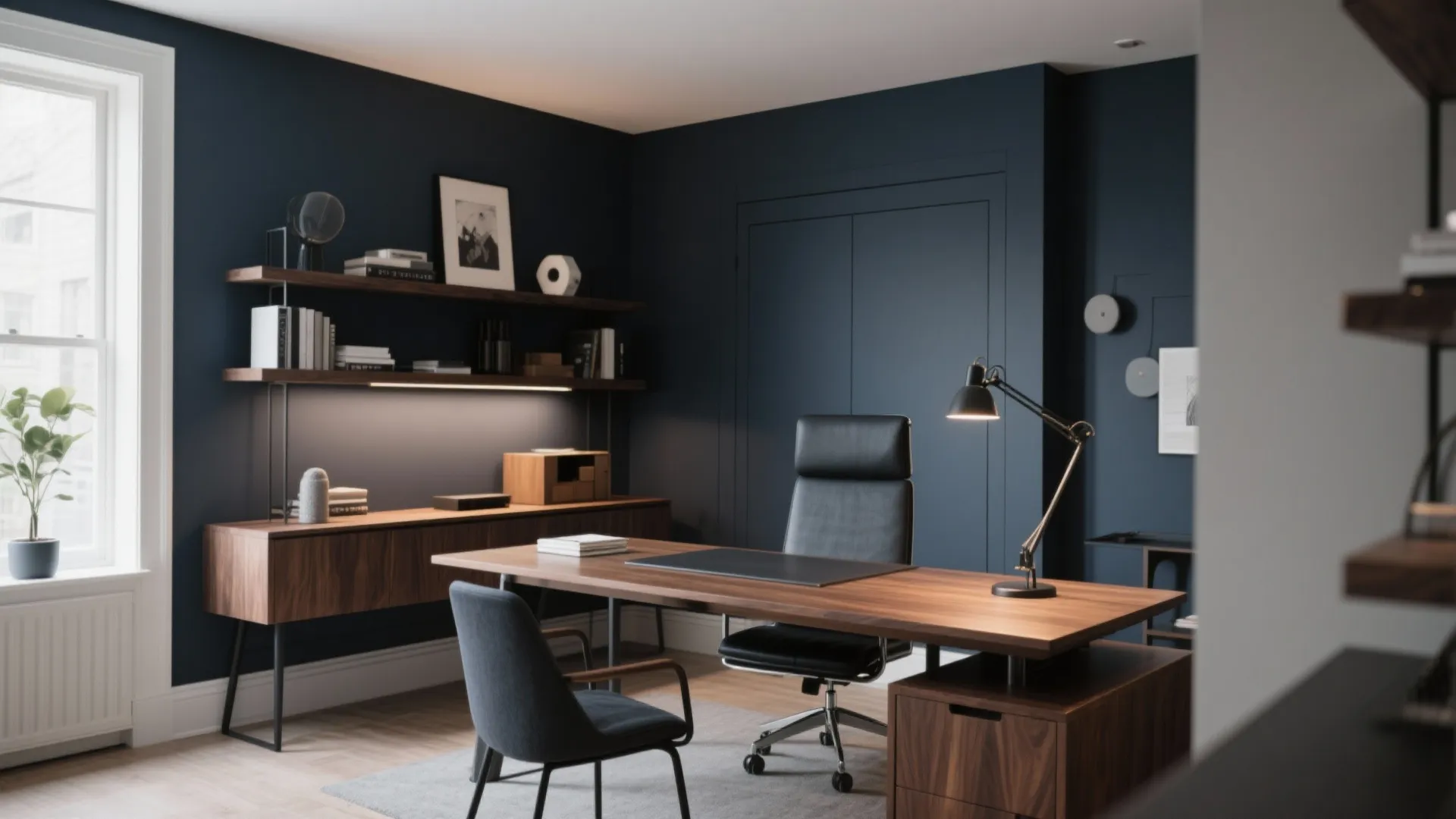 Home office with dark blue walls wooden desk black leather chair and wood wall shelves
