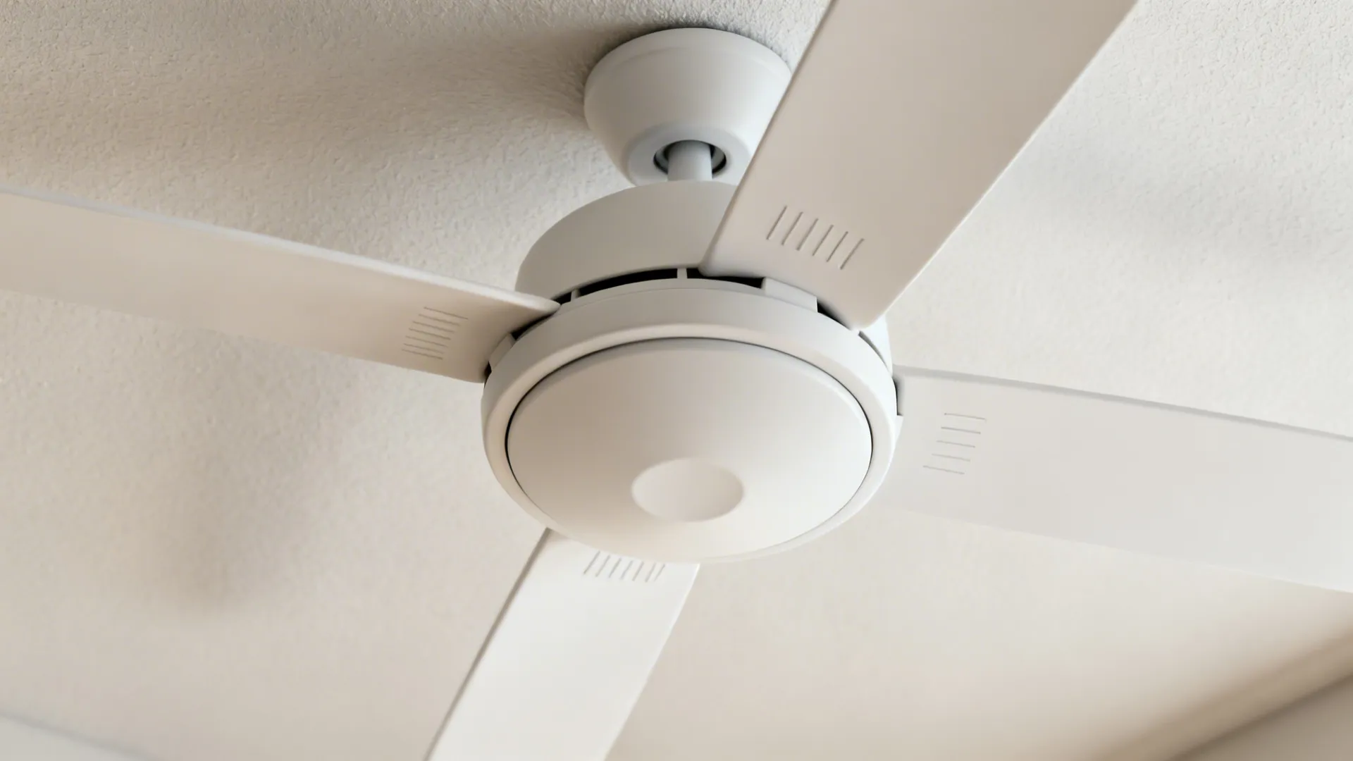 Close-up of a matte white DC ceiling fan blade and hub showing precise pitch and finish.