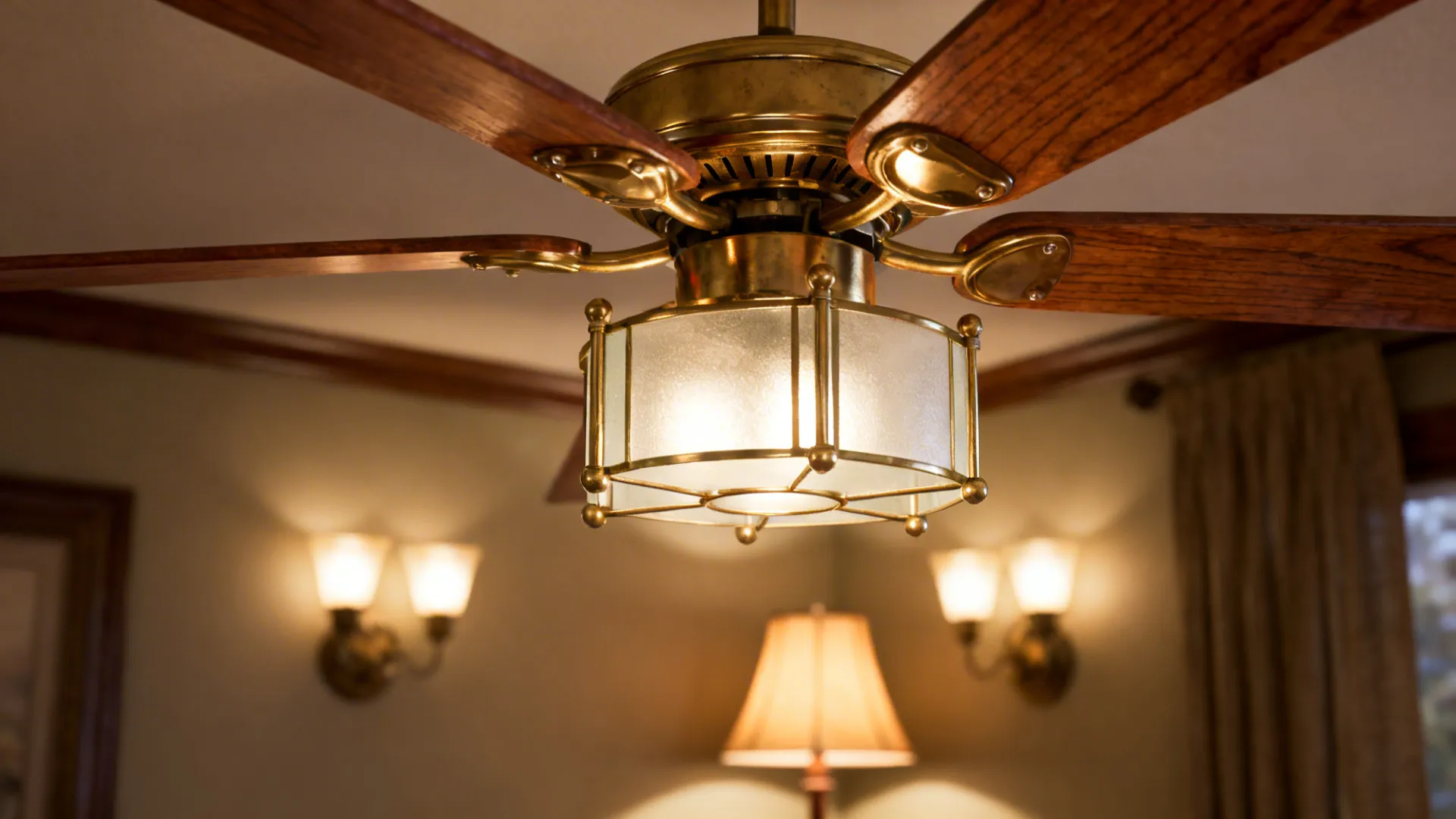 Close up view of brass ceiling light fan with wooden blades and warm wall lights