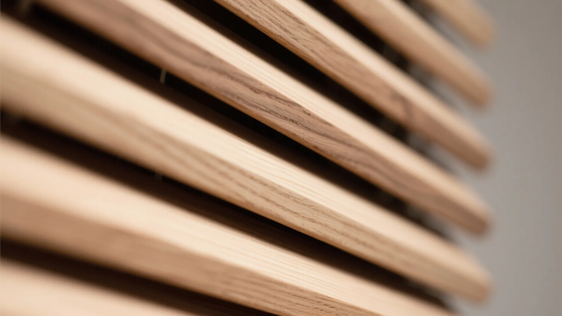 Macro detail of oak slat diffuser with varied depths and smooth rounded edges.