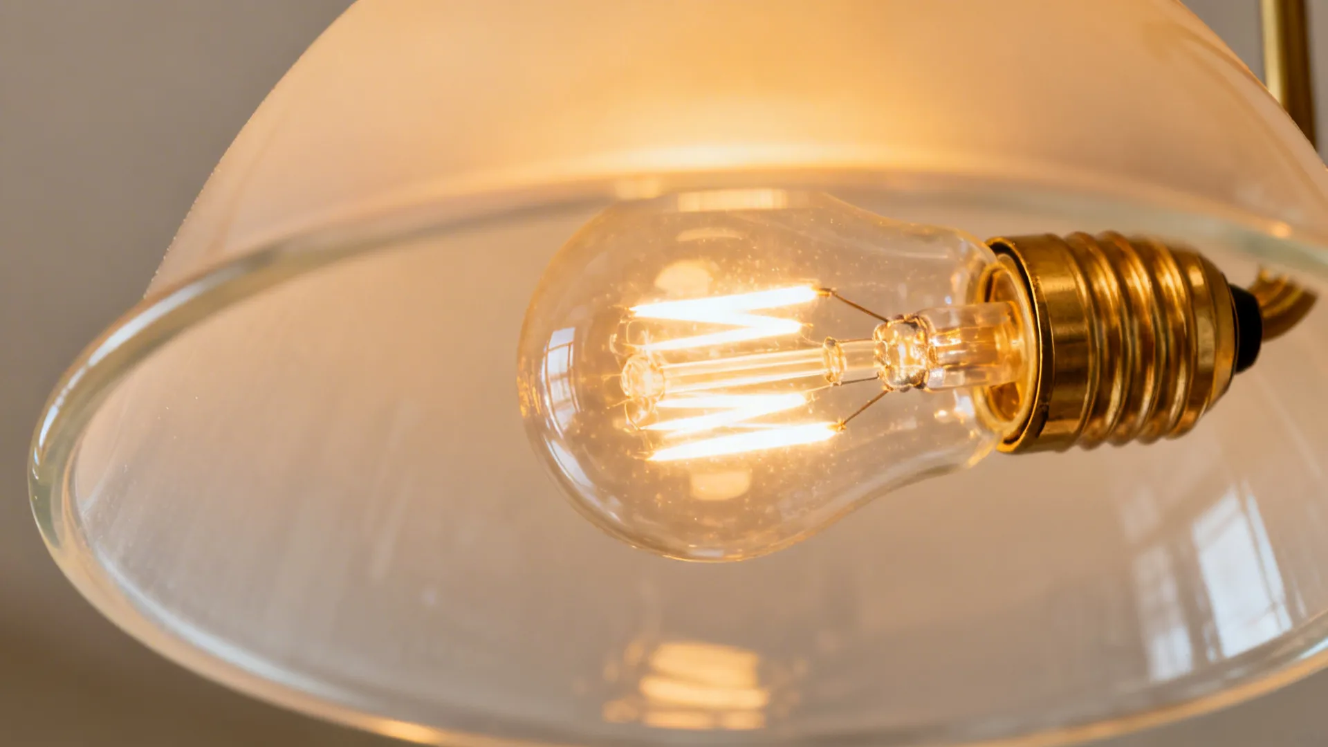 Macro of a warm 2700K dimmable LED bulb glowing behind a frosted chandelier shade.