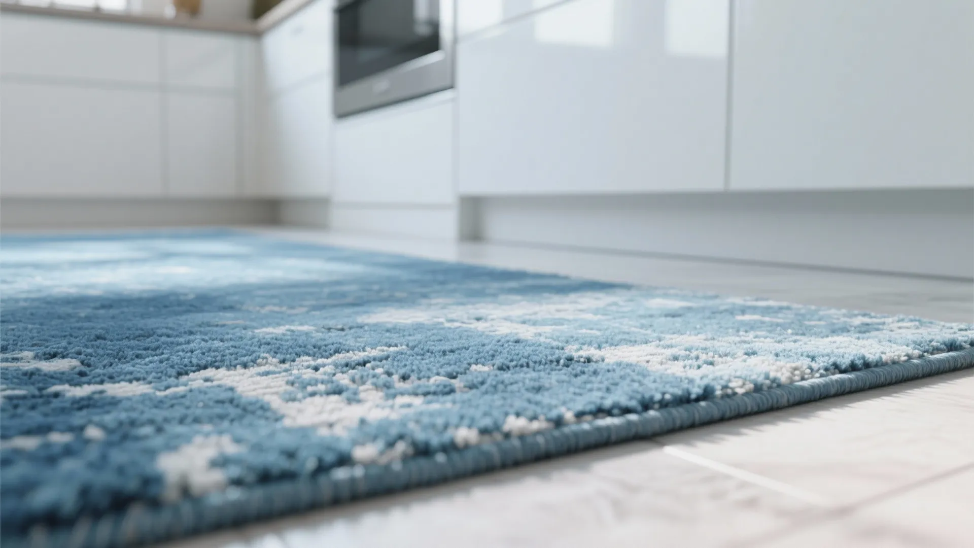 Low angle view of blue and white textured rug on floor in white modern kitchen