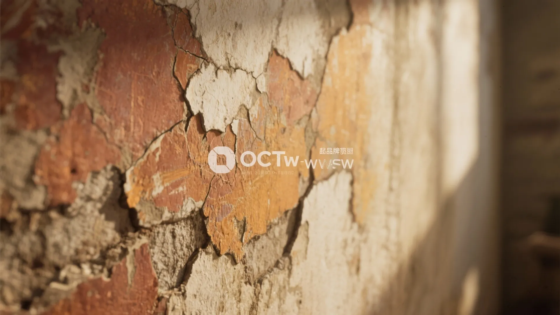 Close-up of aged plaster wall with layered distressed paint in warm hues