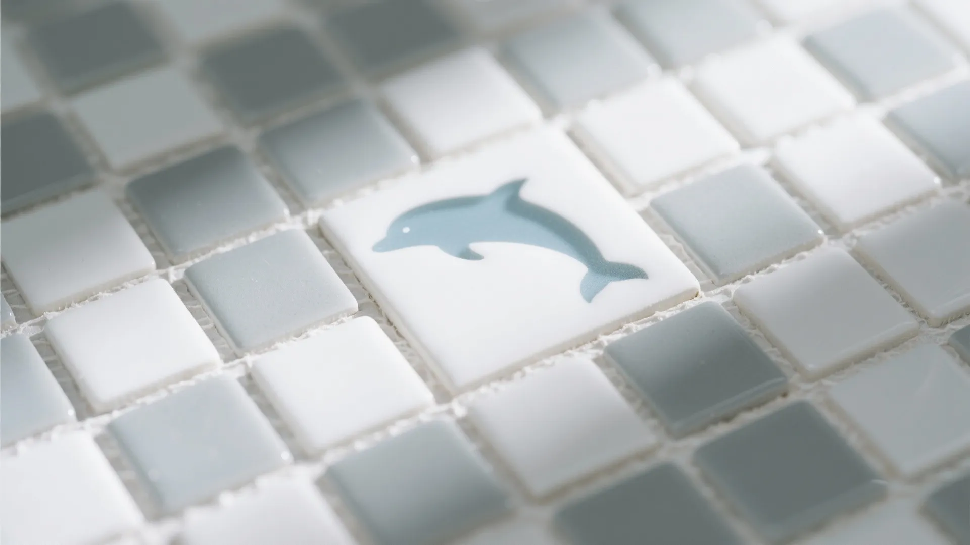 Small white and grey square mosaic tiles with a central tile showing a blue dolphin