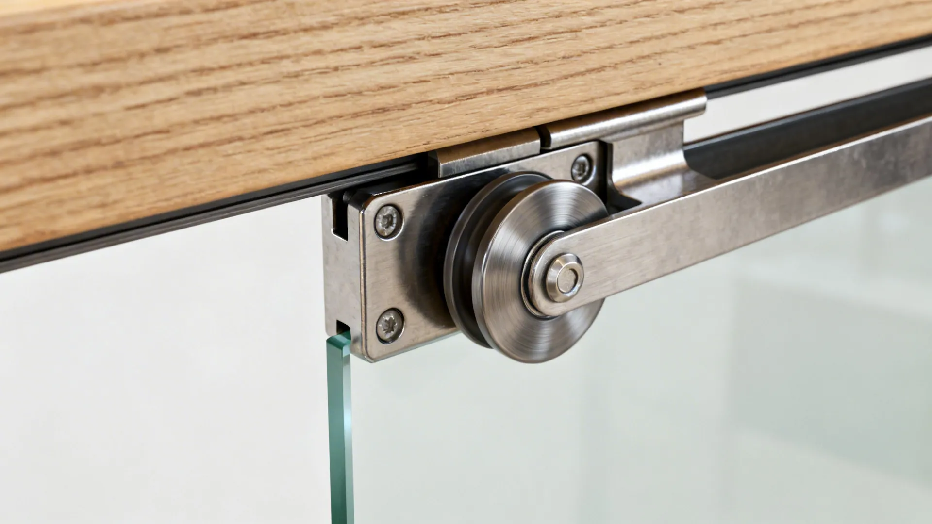 Macro of pocket door roller and track with frosted glass panel edge and wood jamb.
