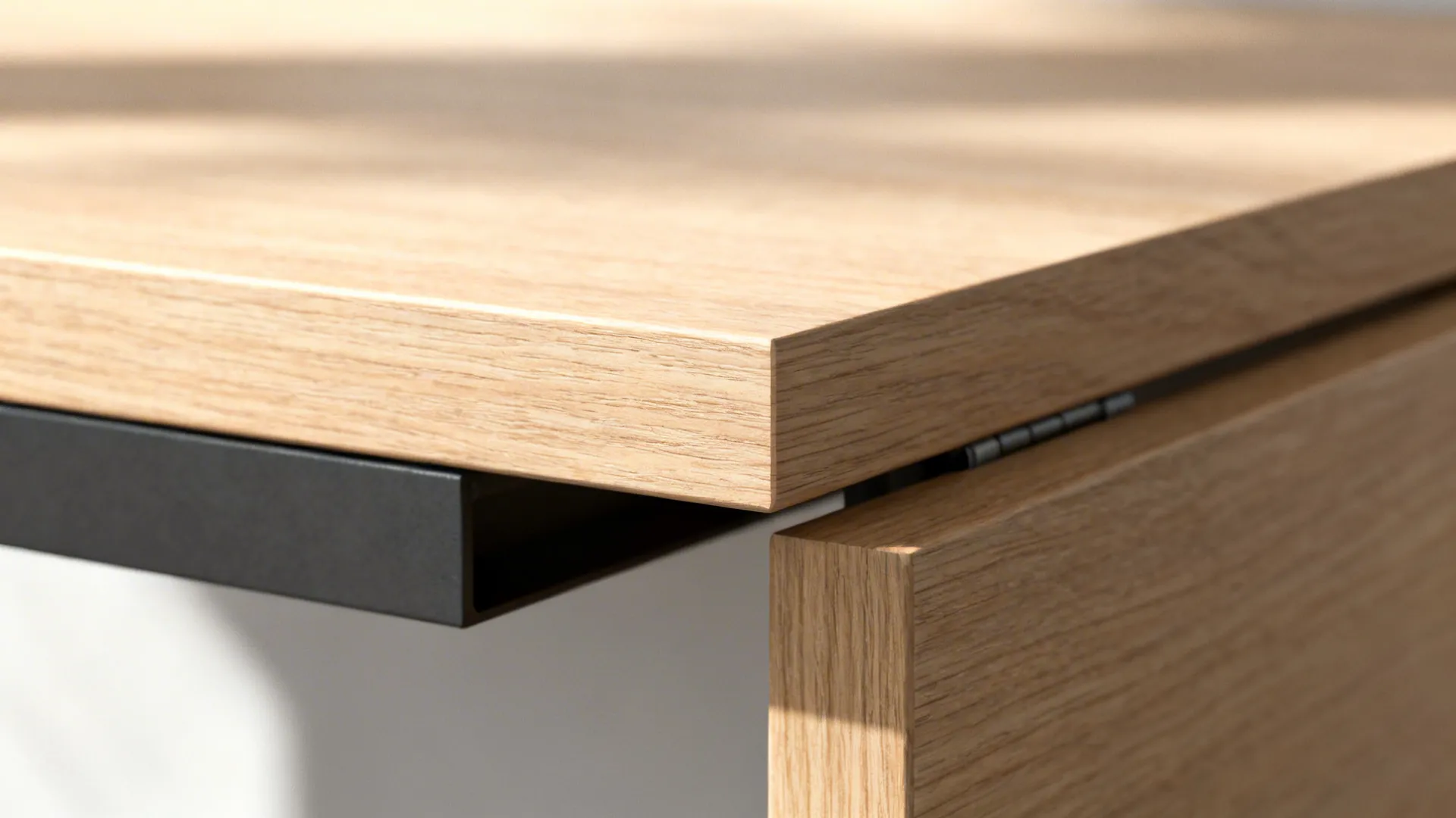 Macro of chamfered drop-leaf table edge and concealed bracket in light oak.