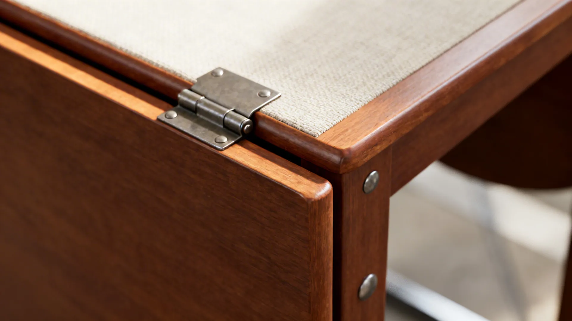 Close-up of drop-leaf table hinge and light wood grain with soft daylight.