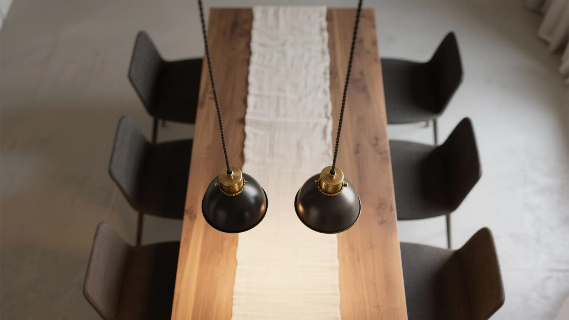 Top-down of a small dining table with two mini pendants evenly spaced, aligned cords and warm balanced light.