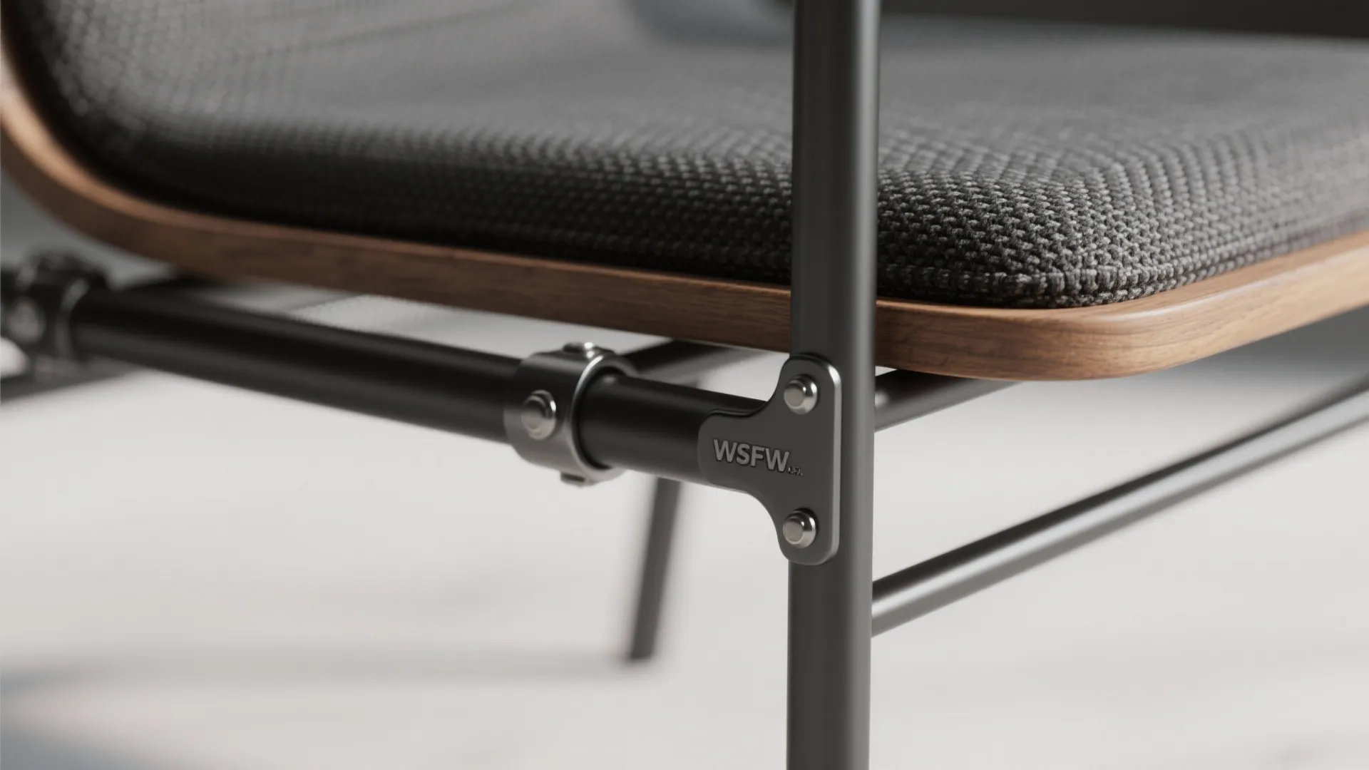 Detailed view of a chair showing black metal frame joints, wooden base and grey fabric cushion