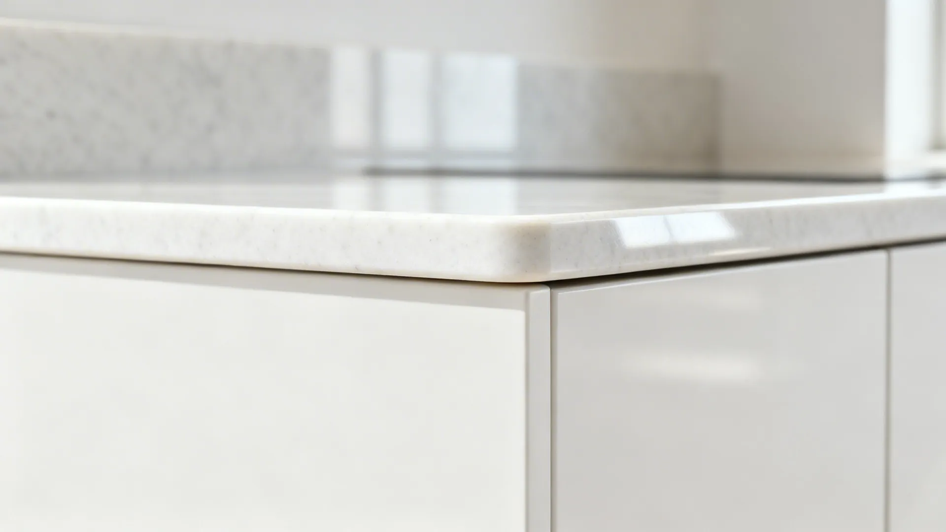 Macro detail of a white quartz eased edge with a small radius and matching upstand.