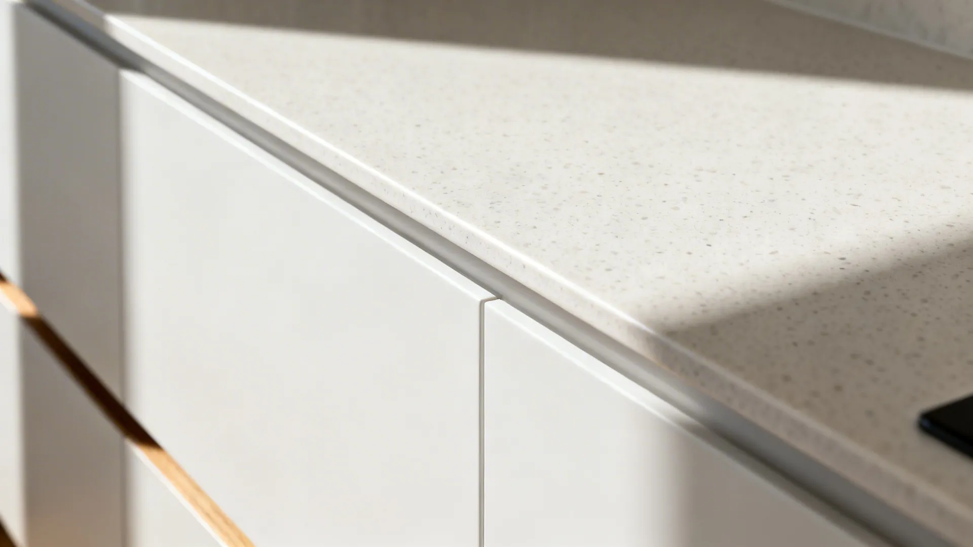 Macro of slim eased countertop edge with a subtle shadow reveal above cabinet.