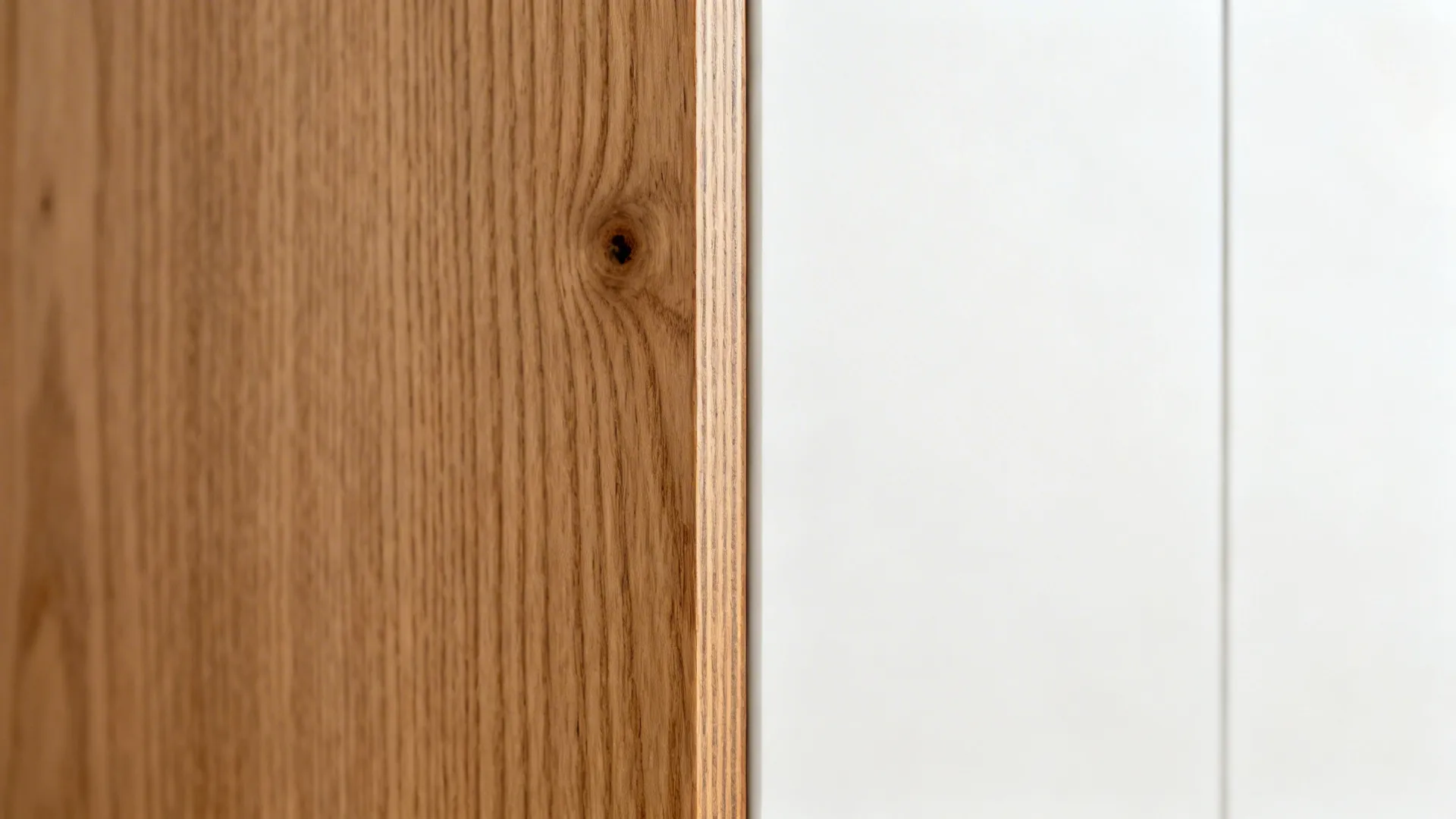 Close-up of rift oak edge-banding on a veneered door with a clean reveal to a white panel.