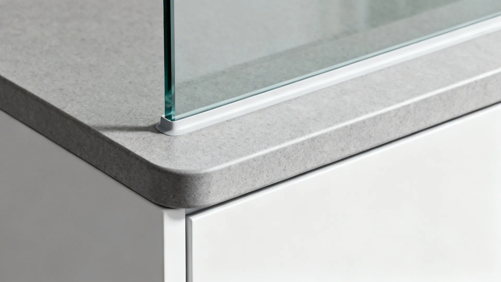 Macro of compact laminate radius edge with ABS edging and integrated upstand against glass.