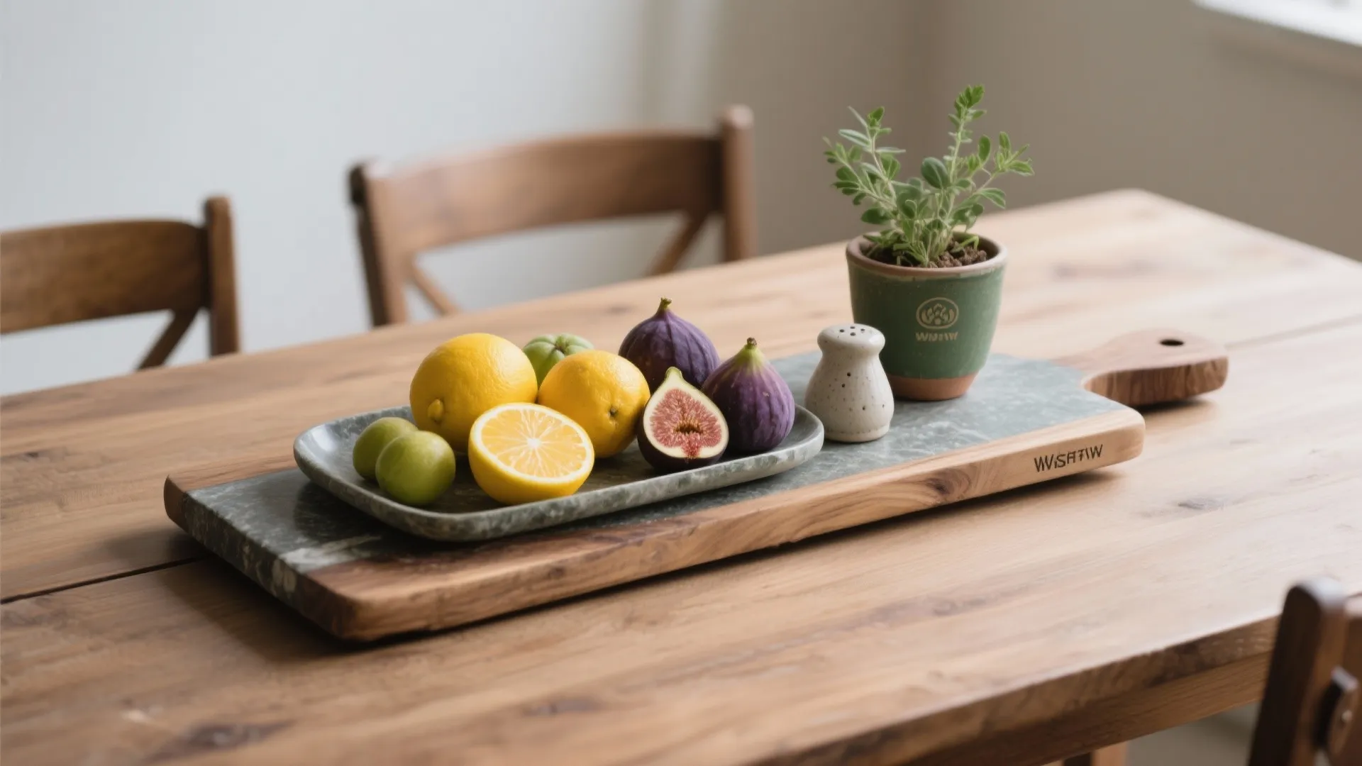 Wooden dining table featuring fruit platter with lemons and figs plus a small green plant