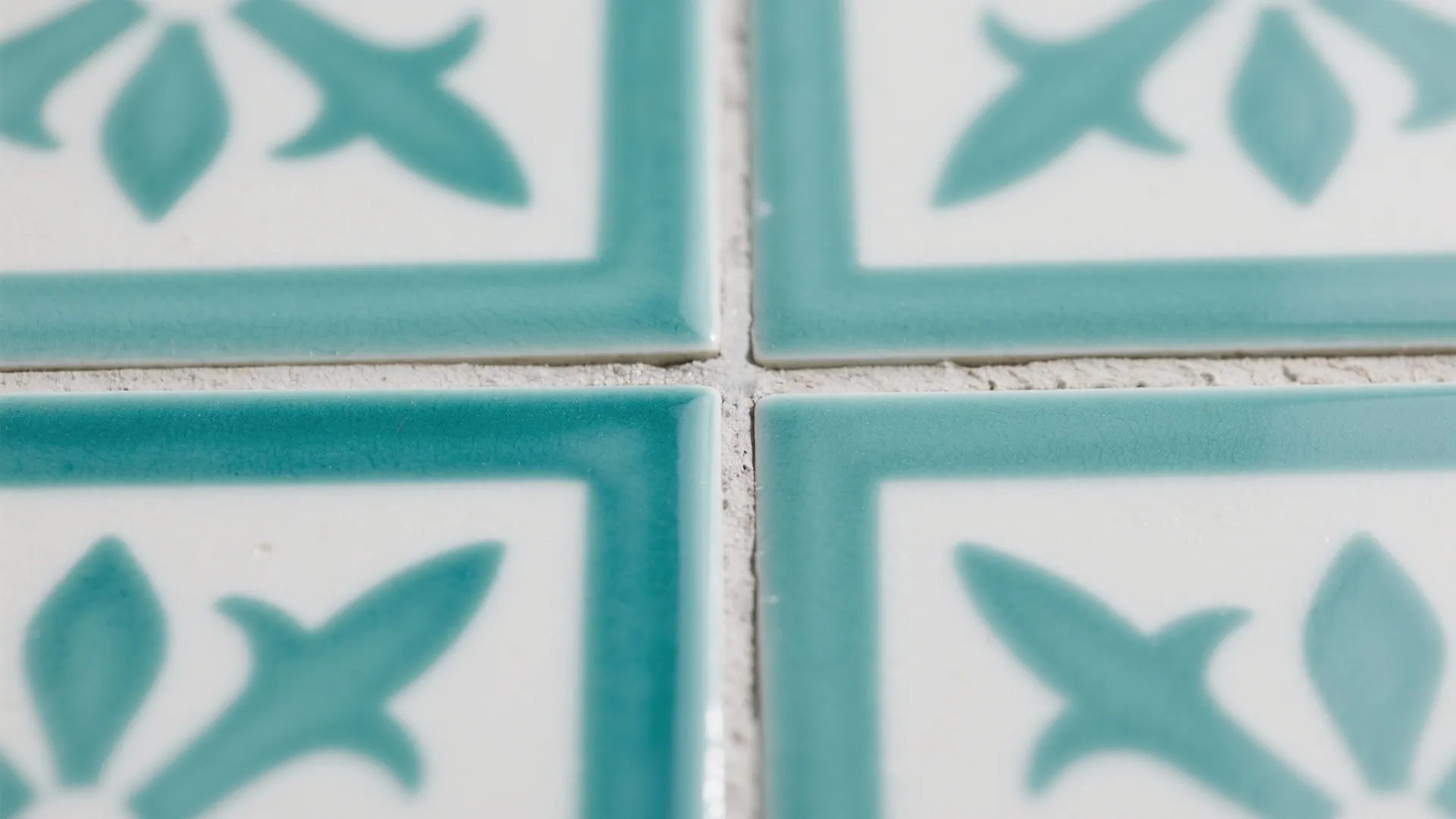 Close up view of white and green patterned tiles with grout lines in between them
