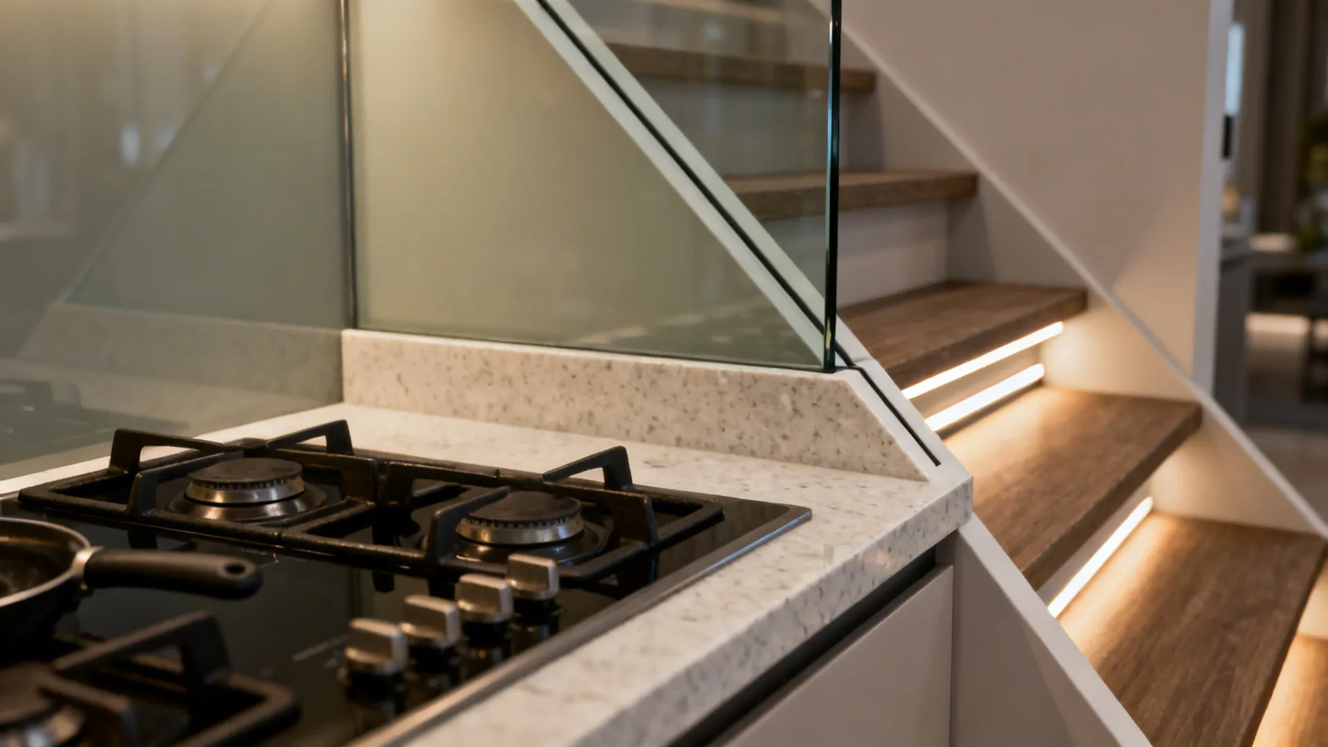 Macro of corner hob alignment, glass backsplash scribe, and LED channel under the stair.