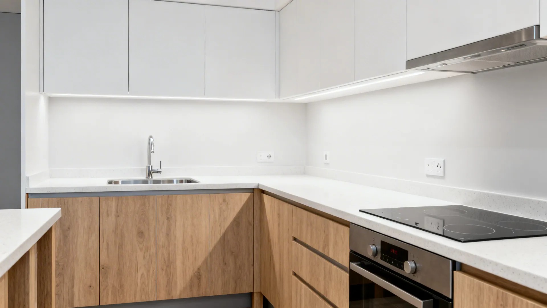Compact kitchen with 900 mm counters and 600–650 mm depth in warm wood and white.
