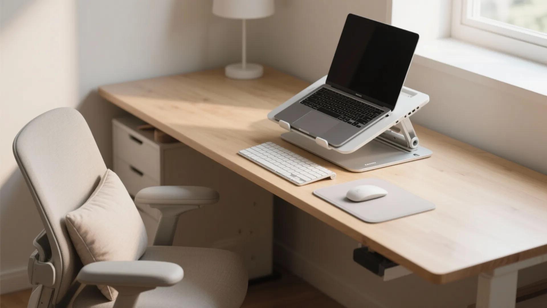 Modern wooden desk with laptop on stand, white keyboard, grey mouse, comfortable chair, and lamp