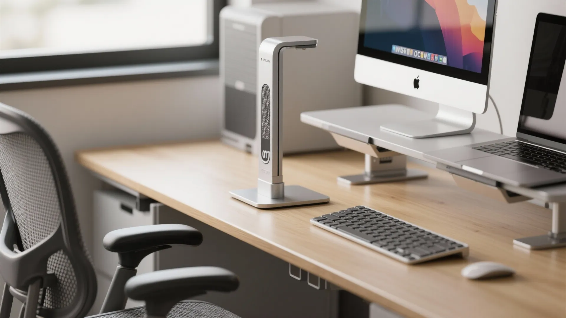 Close-up of an adjustable office chair, sit-stand desk edge, and monitor riser demonstrating micro-office ergonomics.